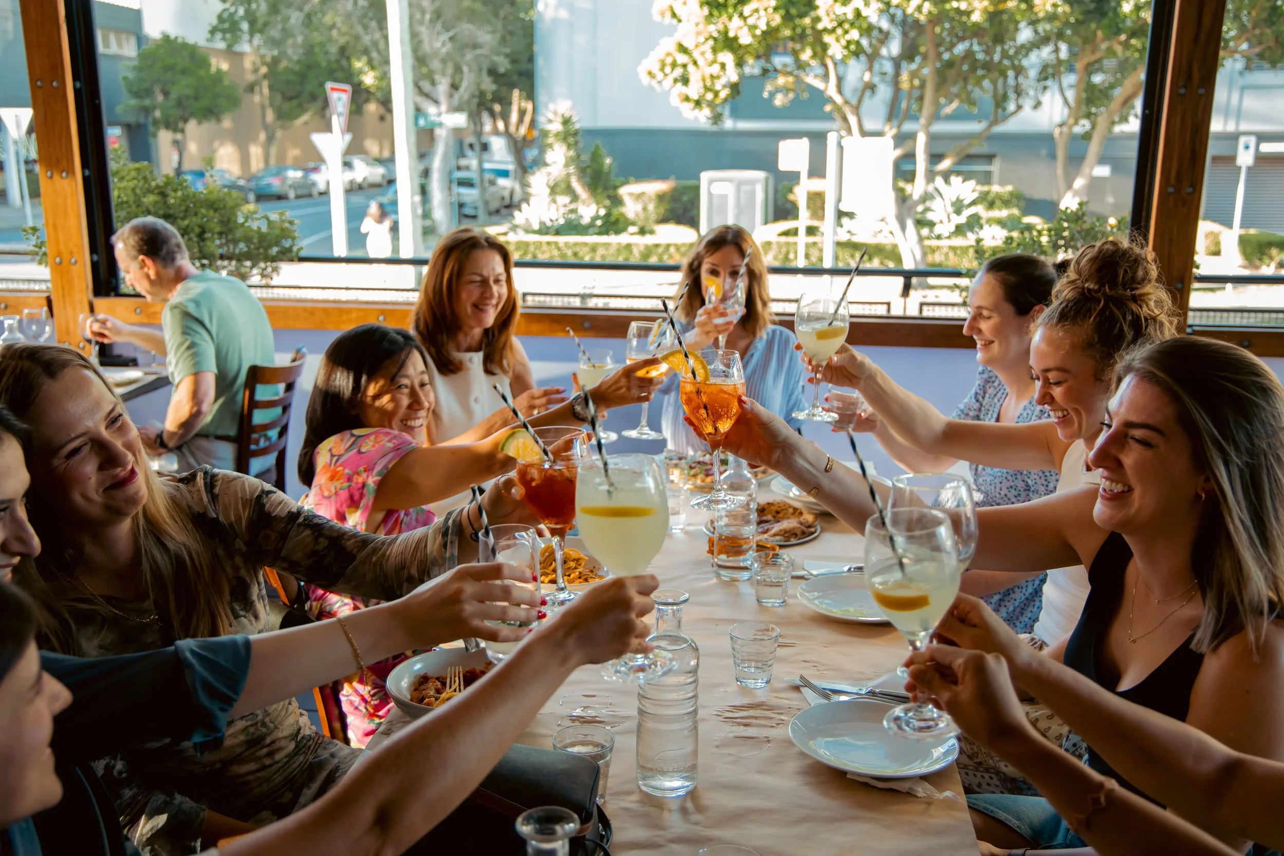 Group dining at Da Mario private event with shared Italian feasting table and wood fired pizzas