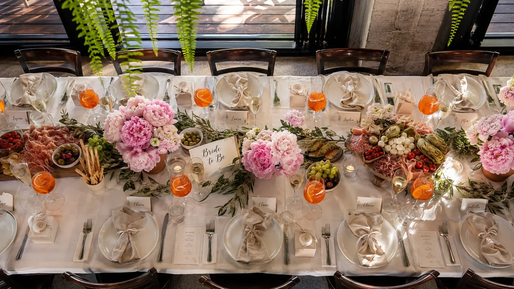 Bridal shower planning table setting with Aperol spritz, antipasto board and olive branch centrepiece at Da Mario Rosebery Sydney