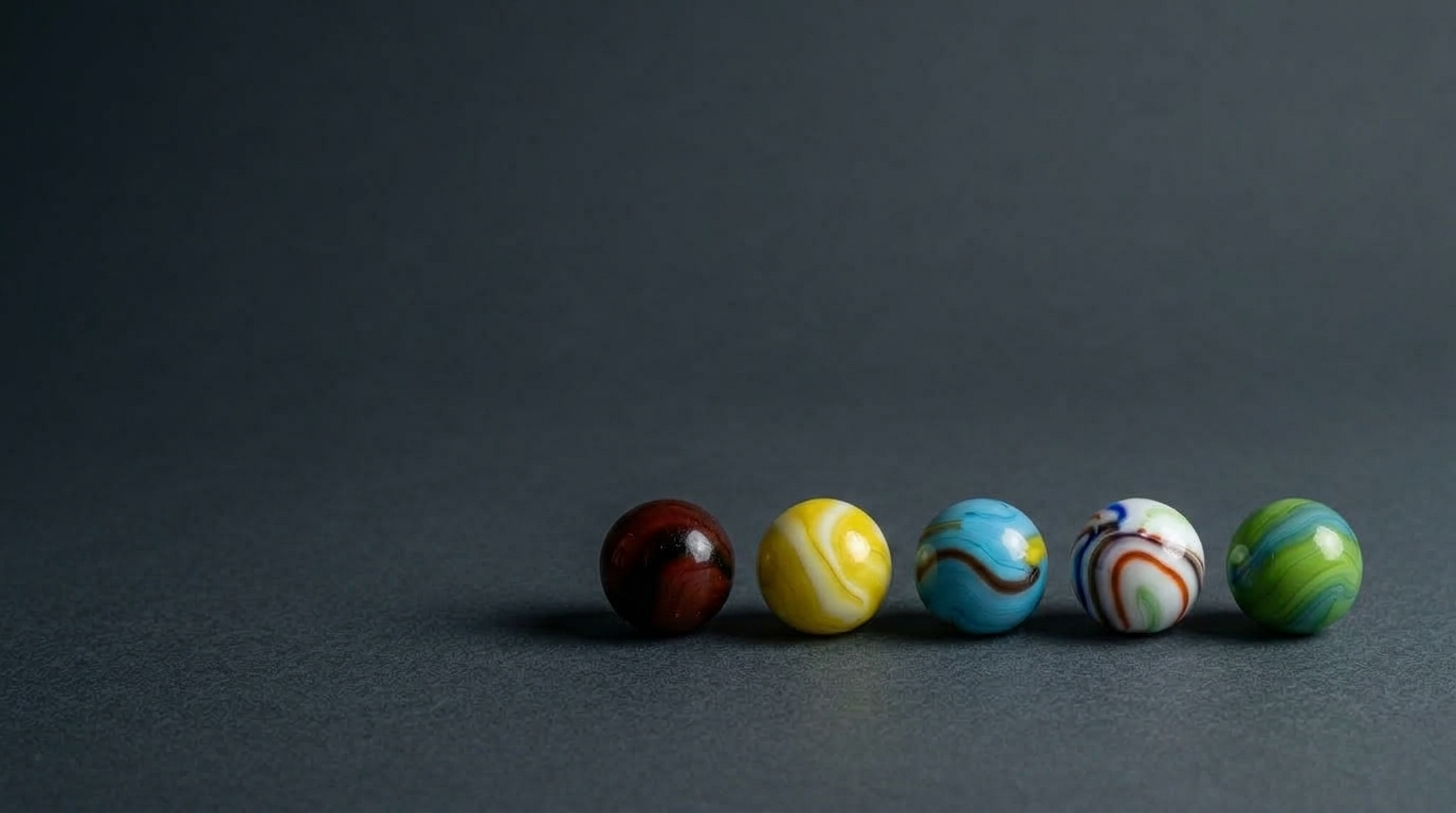 target marbles arranged in a line on a slate grey surface and backdrop
