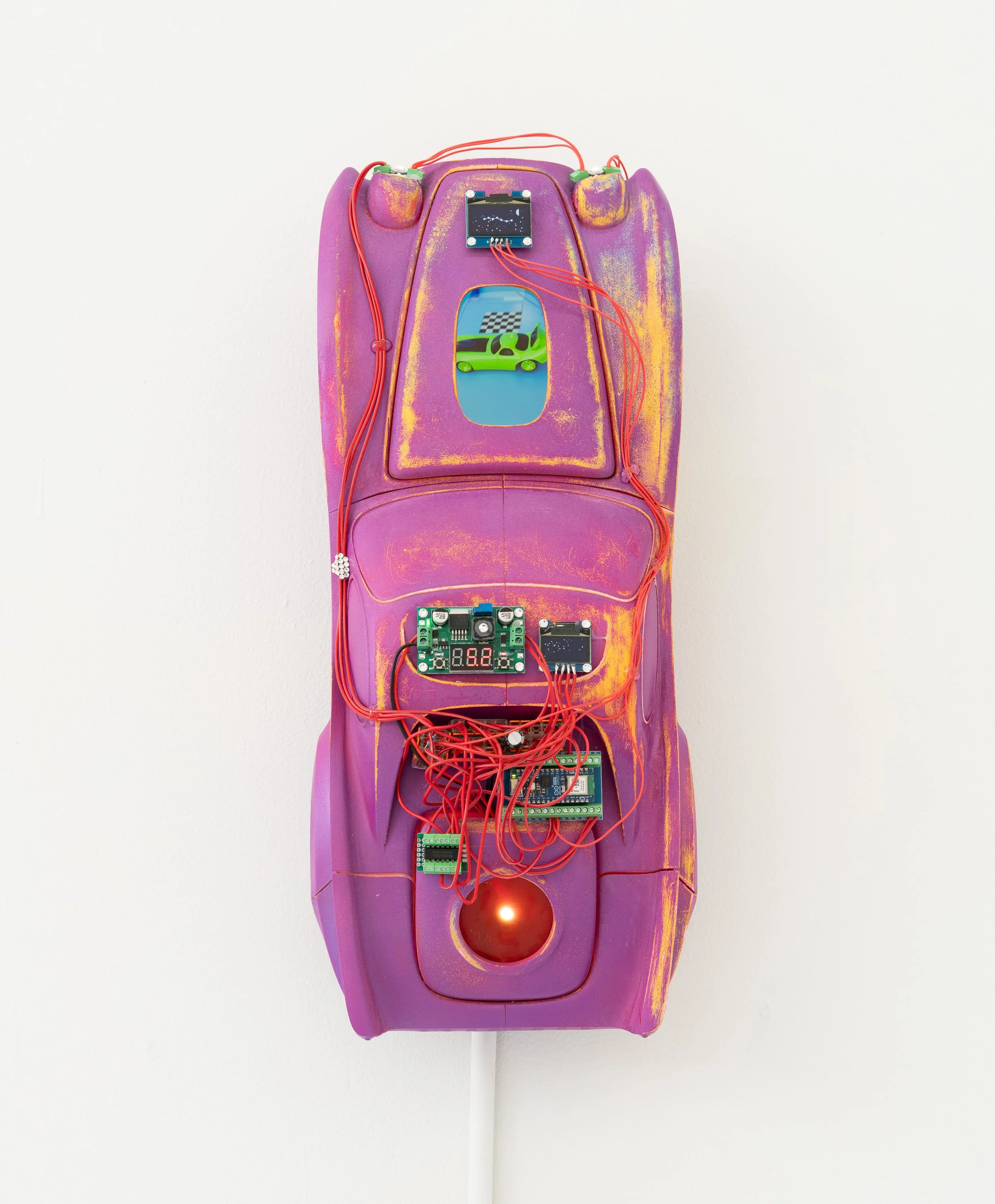 Wyatt Bertz,  Dreaming Car , 2026. 3D-printed PLA car from original design, automotive paint, Raspberry Pi, Arduino, LCD screen, OLED screen, voltage converter, LEDs, 3D animation loop, 24 x 10 x 7 in.