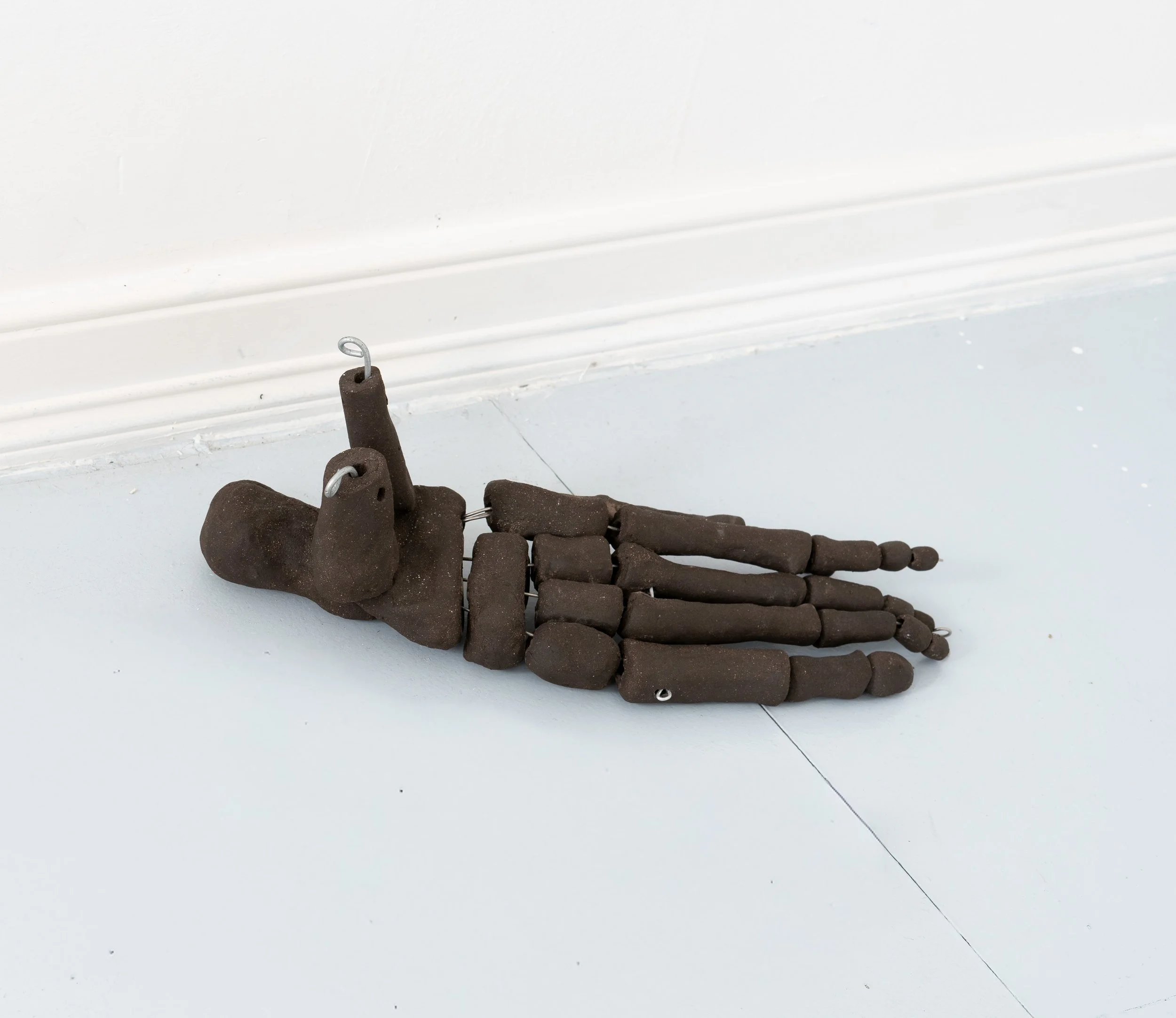 Jared Goldfischer,  Foot of Og , 2026. Black stoneware and steel wire, 5 x 7 x 15 in.