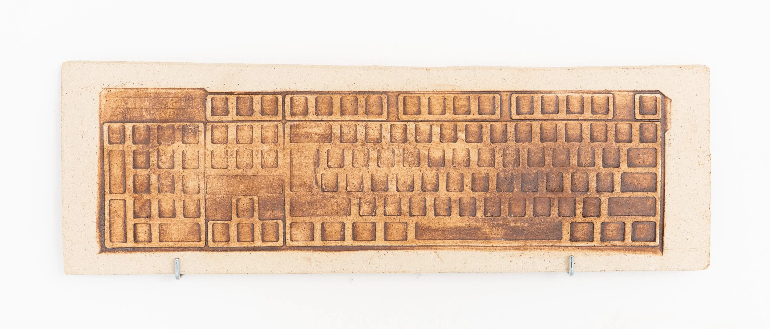 Jared Goldfischer,  Keyboard Fossil , 2026. White stoneware and glaze, 8 x 18 in.