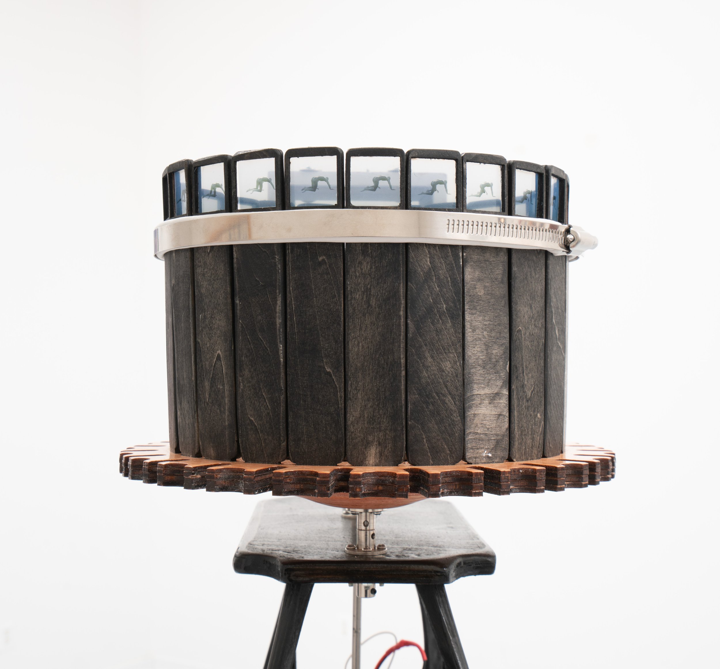 Pat Reynolds,  Slow Crawl , 2025–2026 (detail). Basswood, maple, steel, resin, cement, copper, inkjet prints, fresnel lens, DC motor, hardware, wires, material lift; 24 frames, approximately 24 seconds per full rotation; 64 x 64 x 58 in (height varia