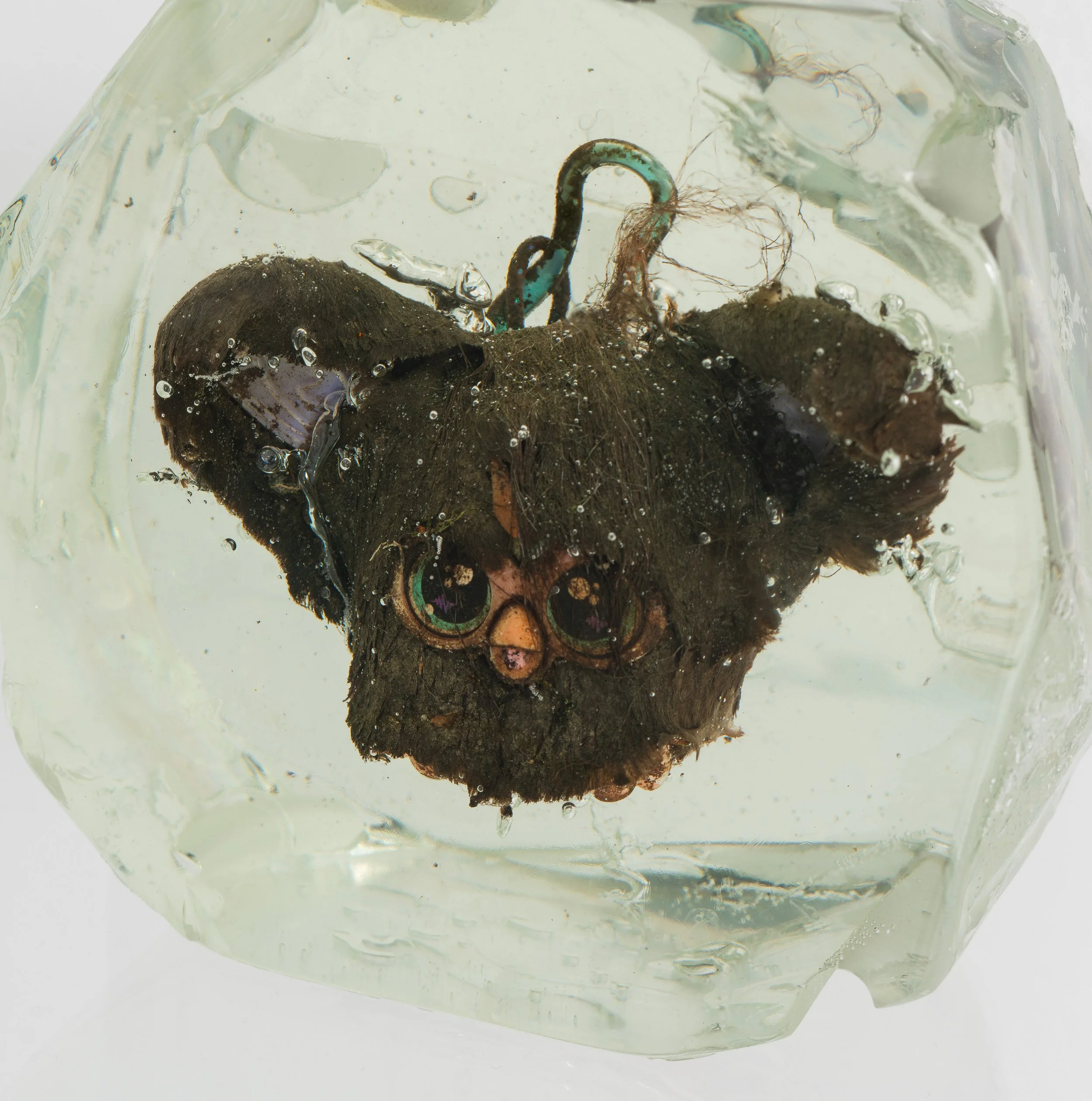 Wyatt Bertz,  Newtown Creek Furblet Iridescent Disco Ball , 2025-2026 (detail). Furby, epoxy resin, sediment from Newtown Creek (August 2025 - May 2026), UV resin, diffraction grating. 4 x 6 x 3 in.