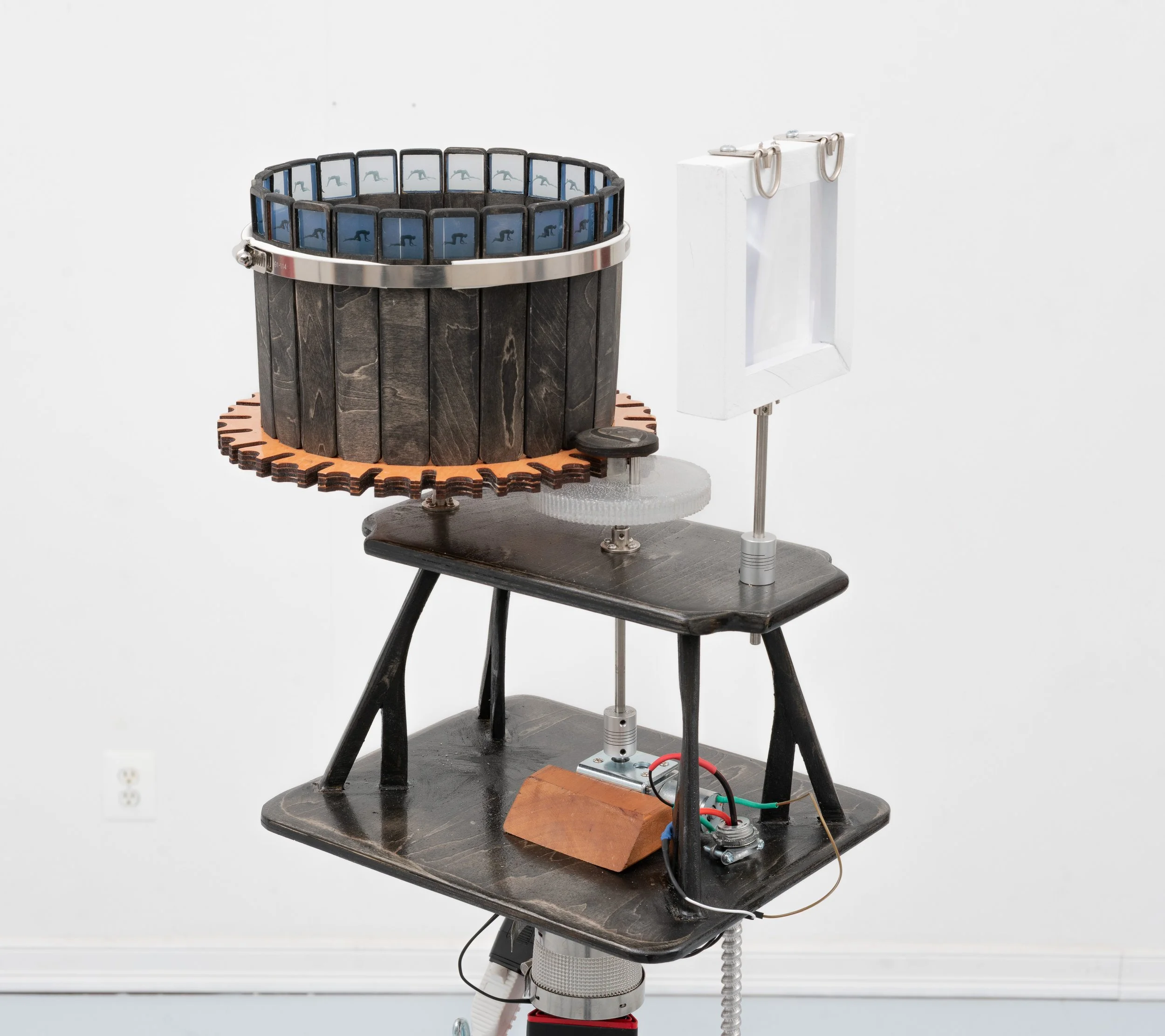 Pat Reynolds,  Slow Crawl , 2025–2026 (detail). Basswood, maple, steel, resin, cement, copper, inkjet prints, fresnel lens, DC motor, hardware, wires, material lift; 24 frames, approximately 24 seconds per full rotation; 64 x 64 x 58 in (height varia