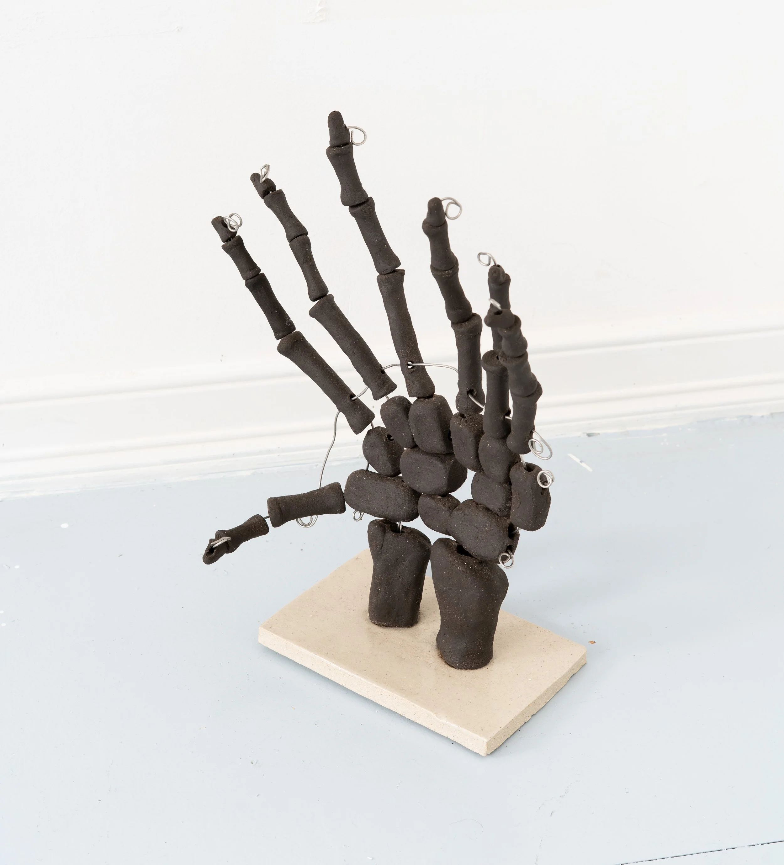 Jared Goldfischer,  Hand of Og , 2026. Black stoneware and steel wire, 15 x 10 x 4 in.