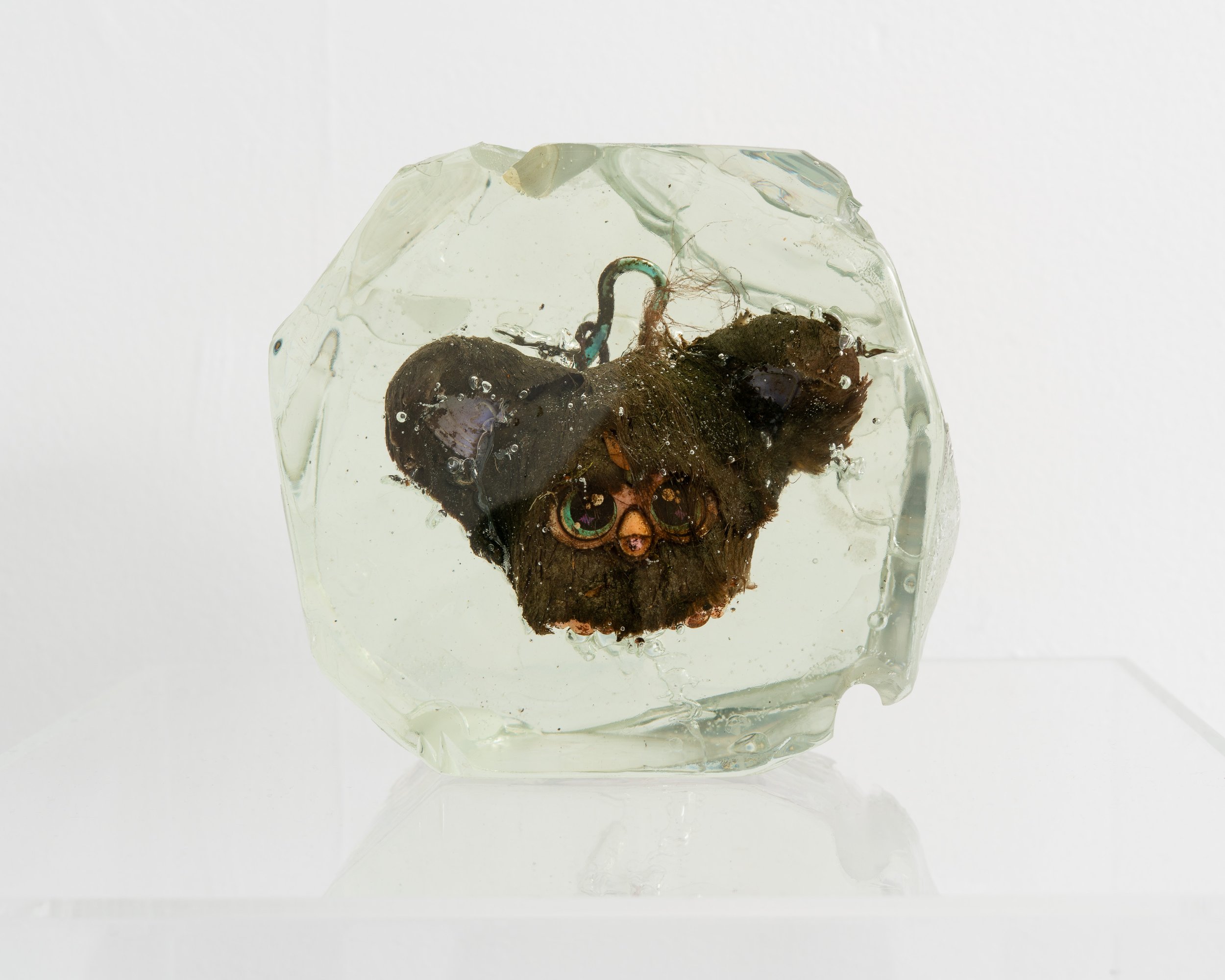 Wyatt Bertz,  Newtown Creek Furblet Iridescent Disco Ball , 2025-2026. Furby, epoxy resin, sediment from Newtown Creek (August 2025 - May 2026), UV resin, diffraction grating. 4 x 6 x 3 in.