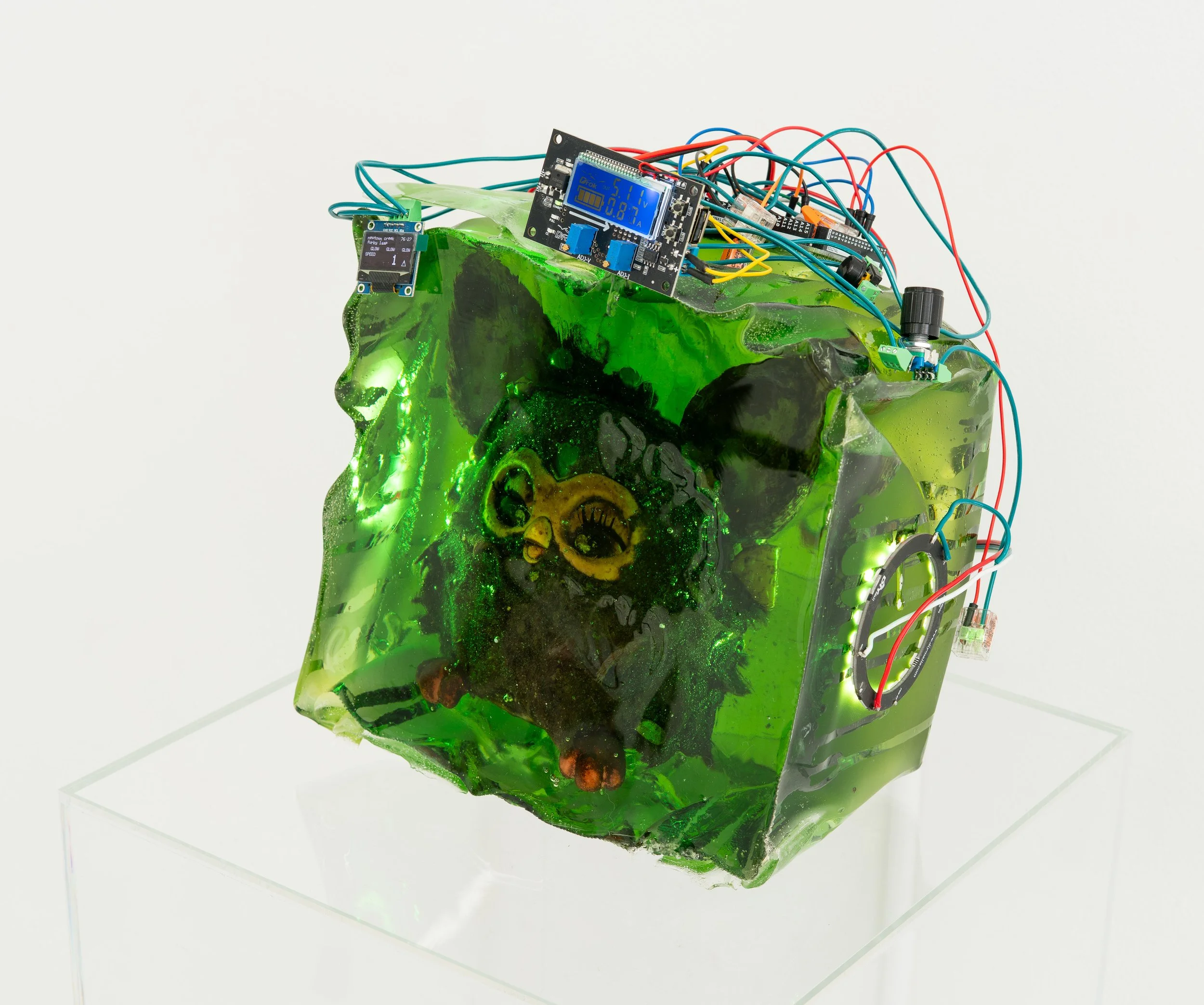 Wyatt Bertz,  Newtown Creek Furby Lamp , 2025-2026. Furby, resin, sediment from Newtown Creek (August 2025 - May 2026), electronics, 7 1/2 x 9 x 8 1/2 in.