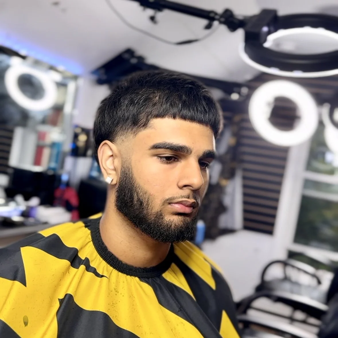 Young man with a fresh haircut sitting in a barbershop or salon.