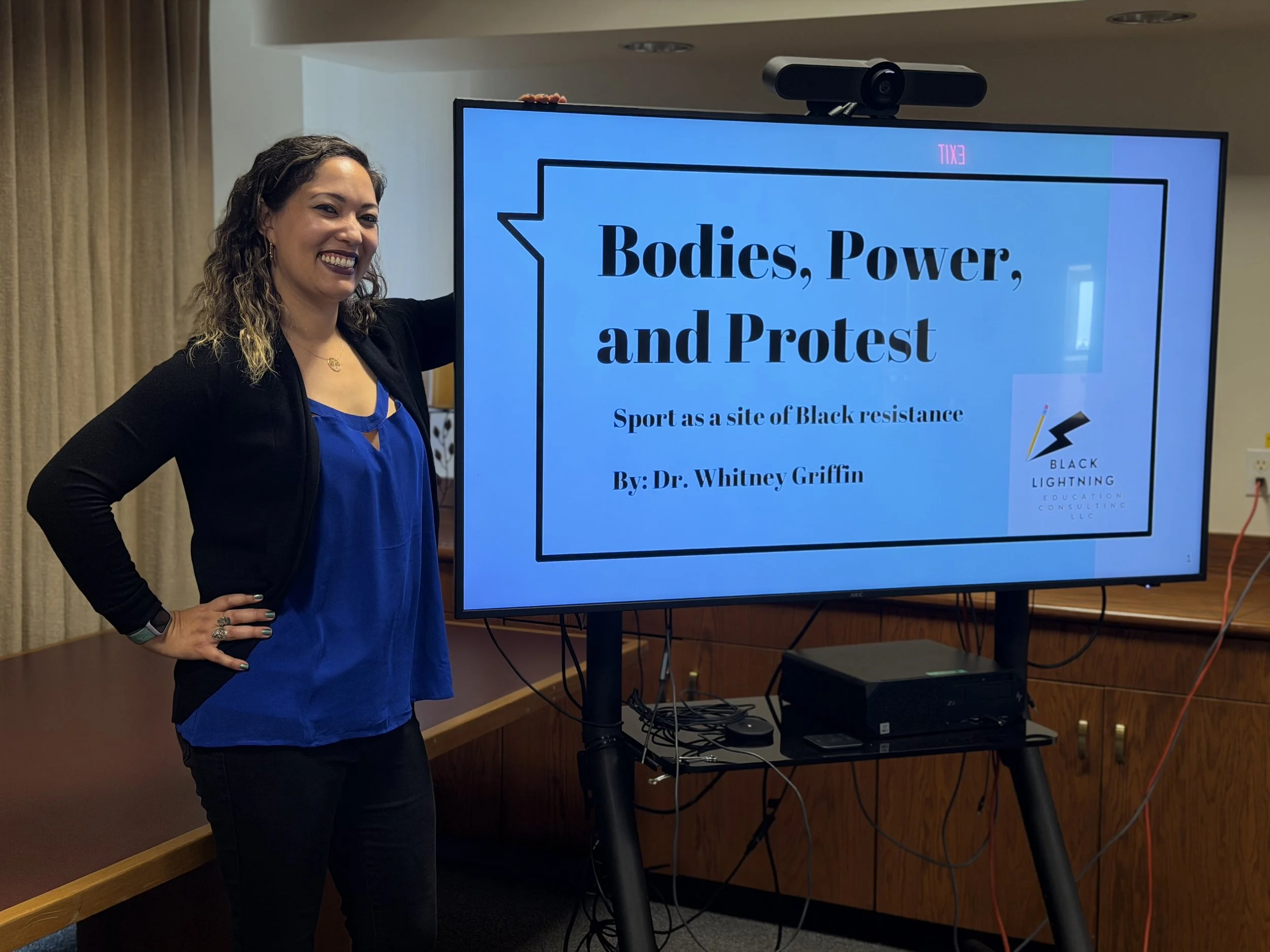 Dr. Whitney standing next to lecture powerpoint.