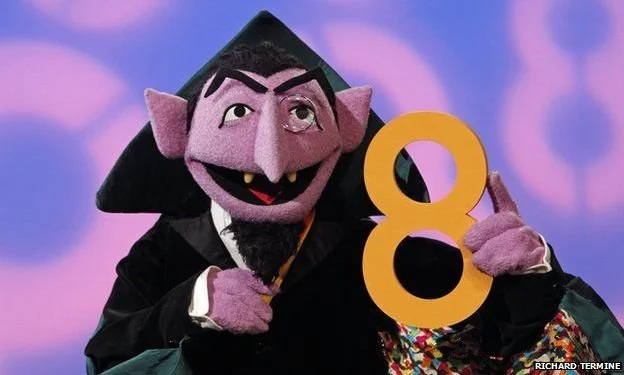 Count von Count holding the number 8.