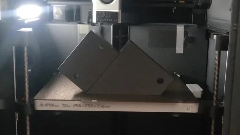 Fotografie van een 3D-printer met een functioneel onderdeel erin. 