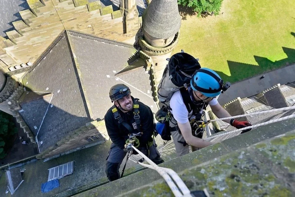 Rope access climbers on ropes abseiling.