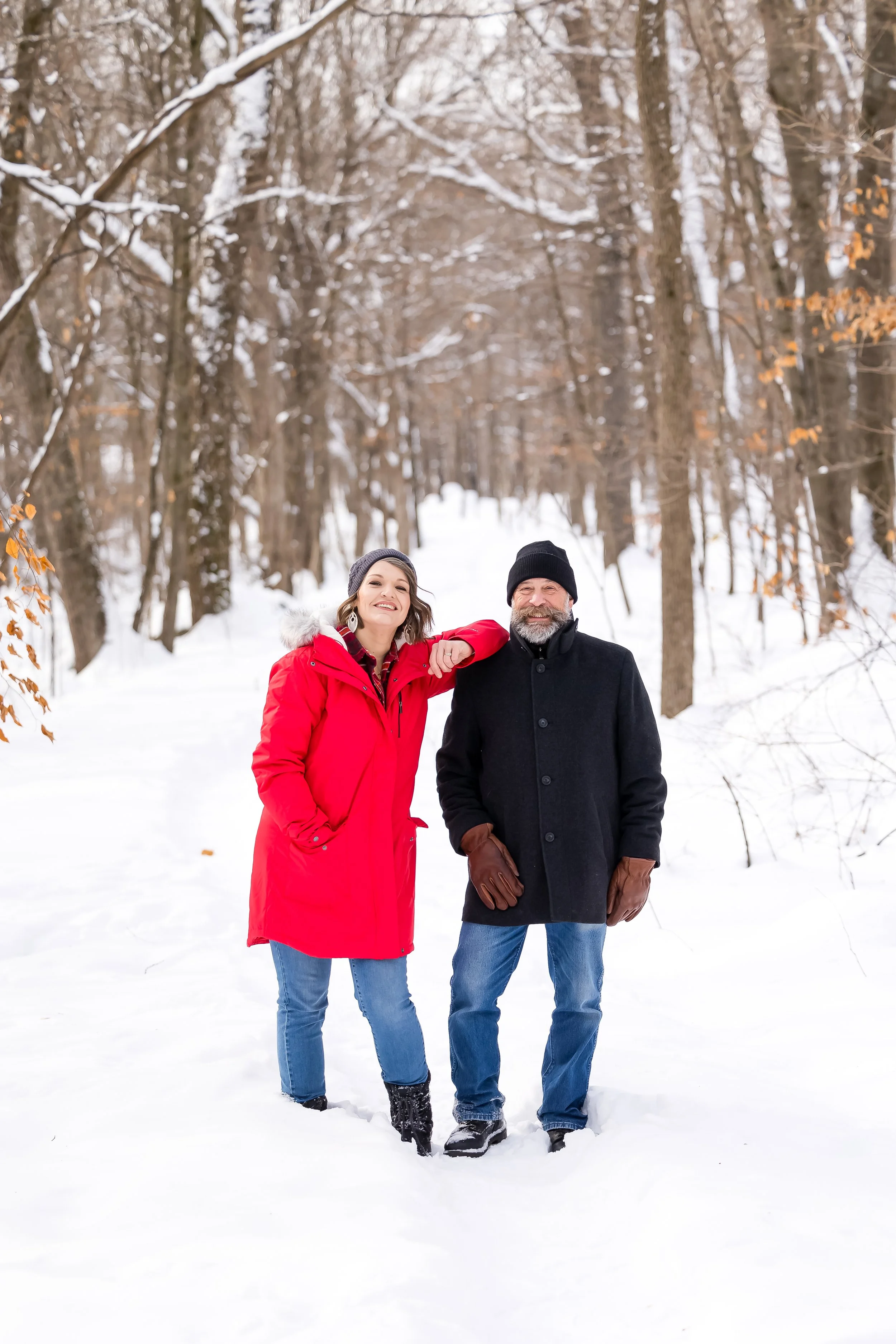 A man performing live music by singing and playing an acoustic guitar in a cozy, warmly lit room with orange wallpaper, framed posters on the wall, a fireplace, a table lamp, and various boxes and equipment around.