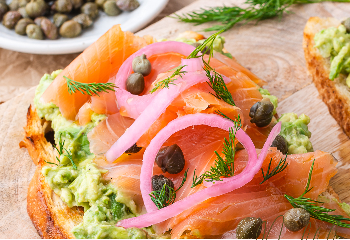 smoked salmon avocado toast with capers, will and pickled red onions