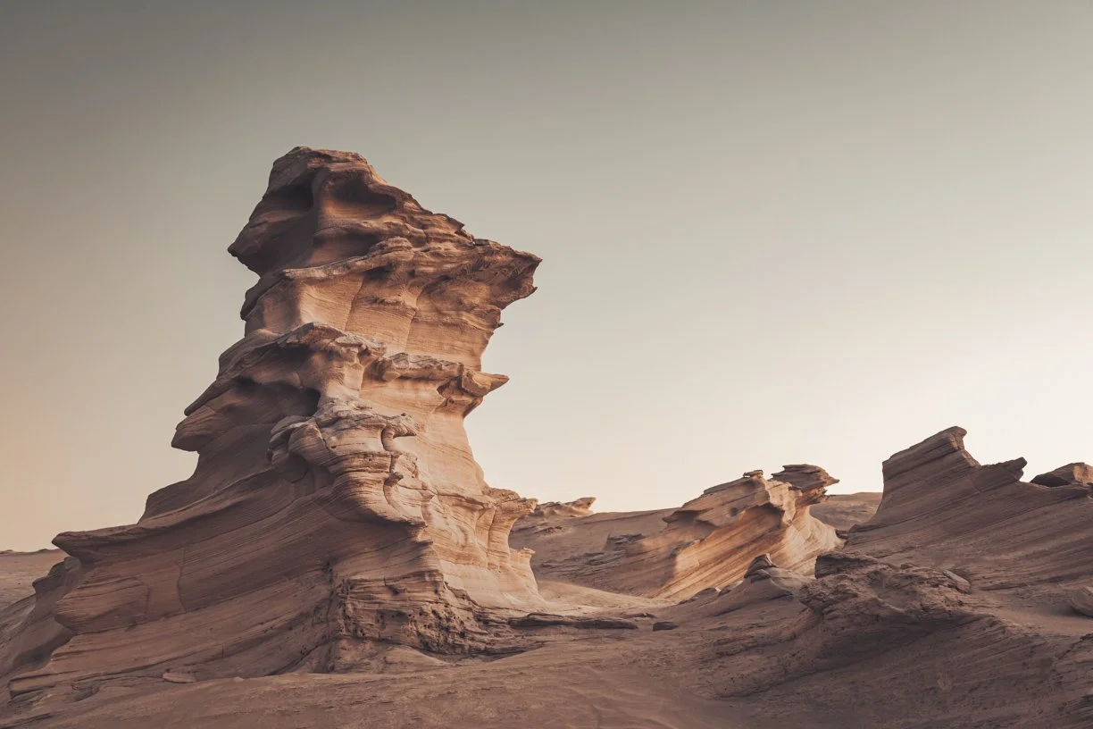 A desert landscape with uniquely shaped sandstone formations and a clear sky.