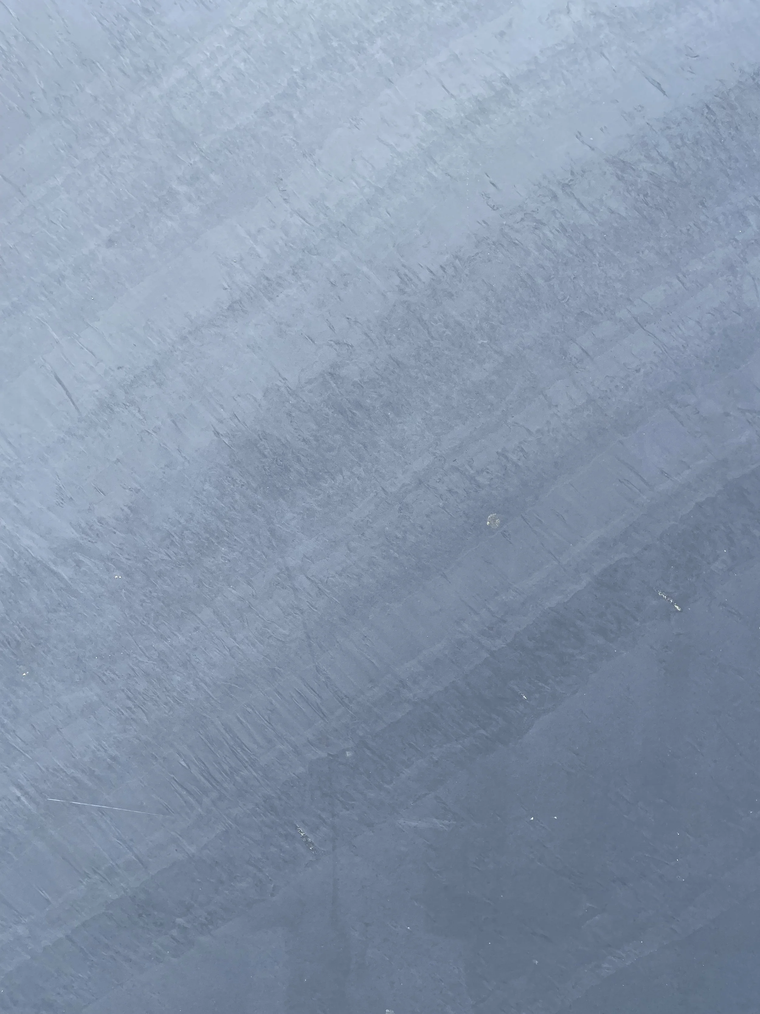 Close up of Welsh Dark Blue Grey Slate, a fine grained natural stone with deep blue grey tones, subtle layered texture and a smooth split face surface.