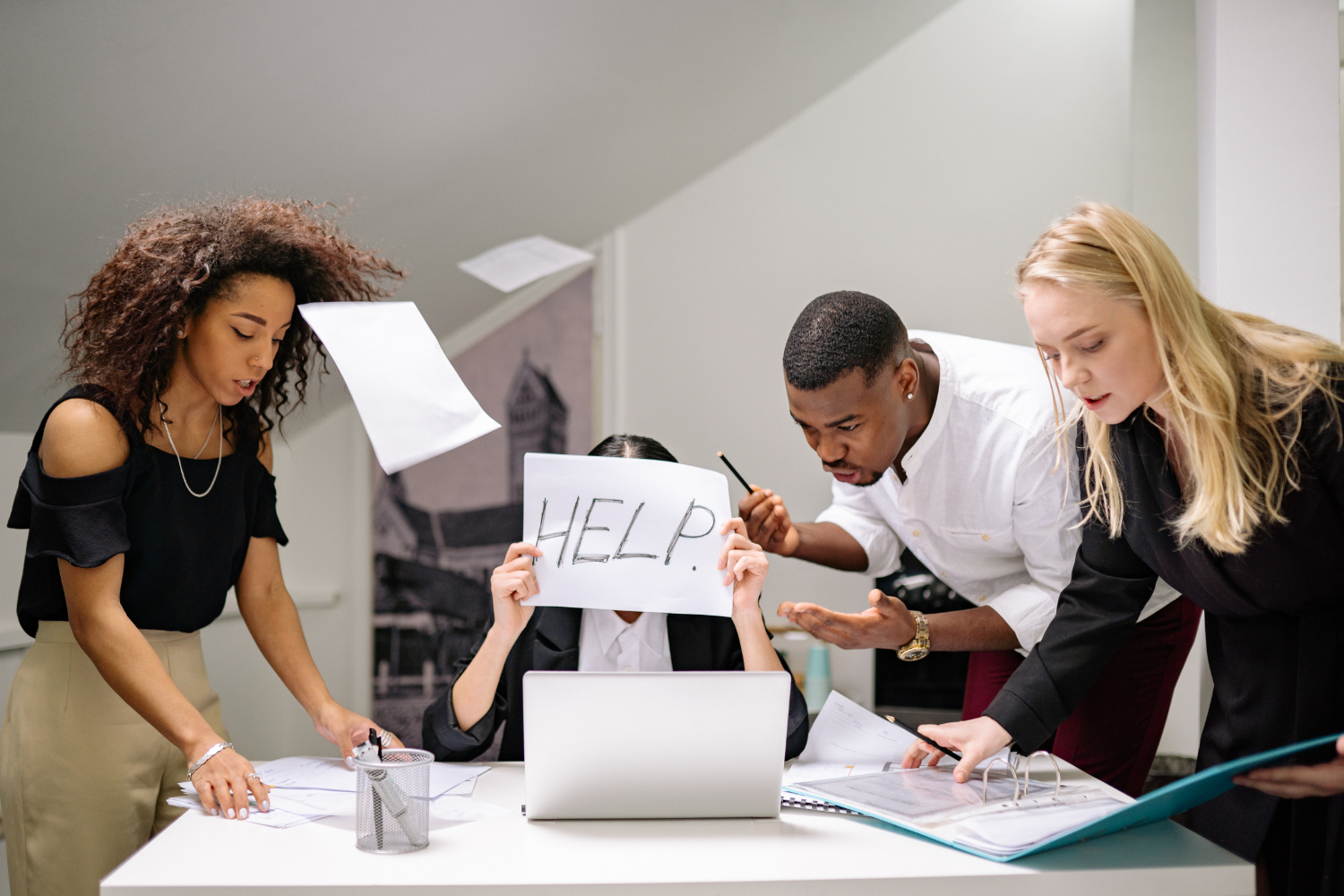 Stressed business owner surrounded by people and holding a help sign