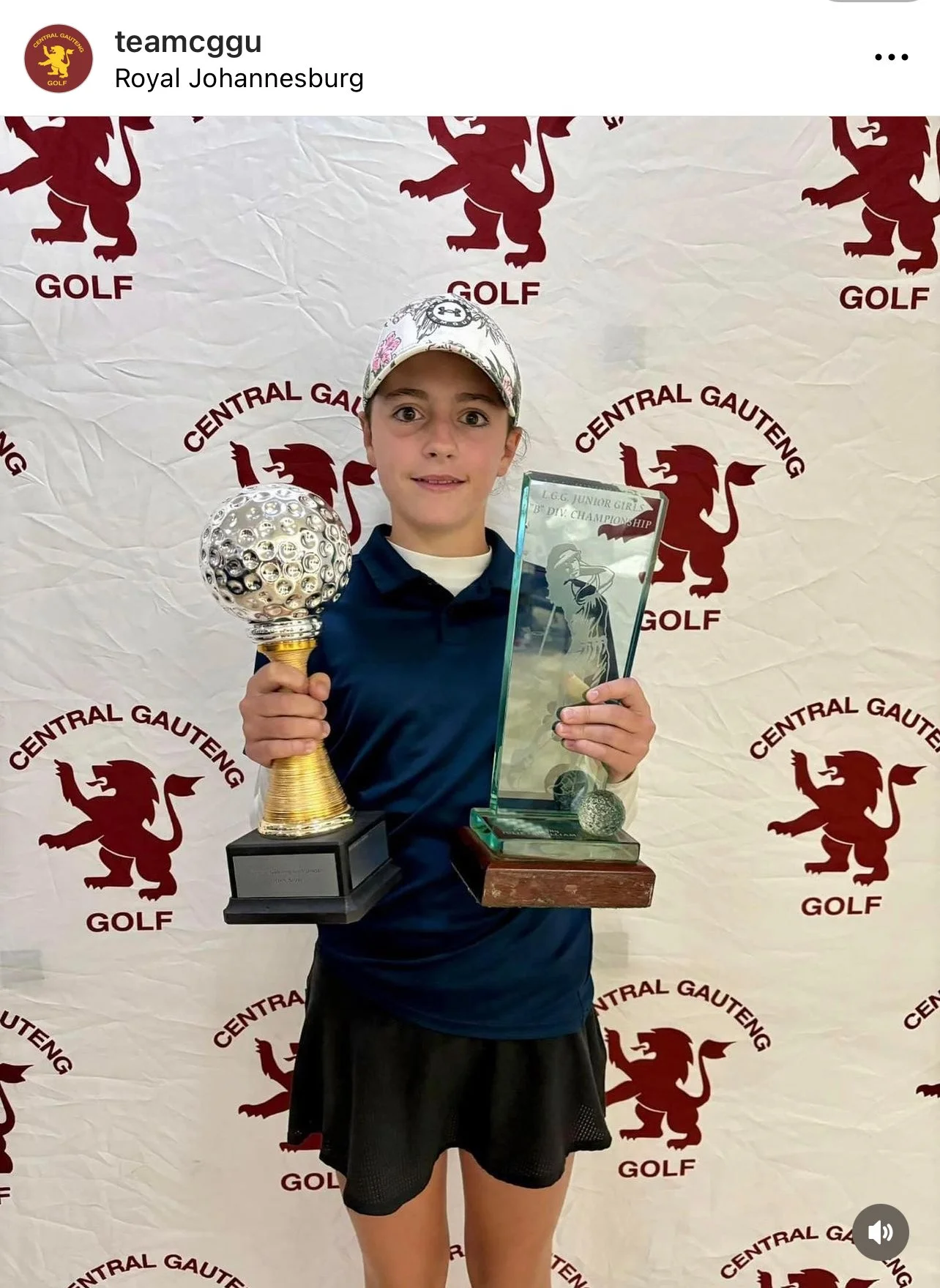 Young girl holding two trophies and a glass trophy in front of a backdrop with a lion logo and the text 'Central Gauteng Golf.'
