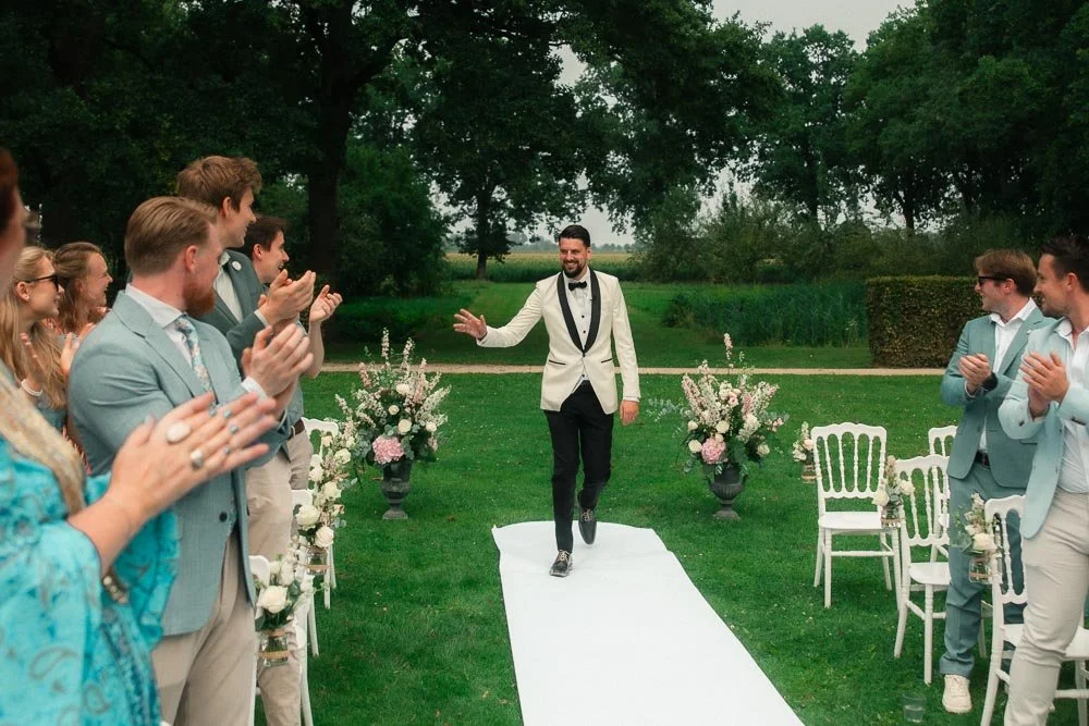 Bruidegom loopt richting de ceremonie bij Kasteel Dussen