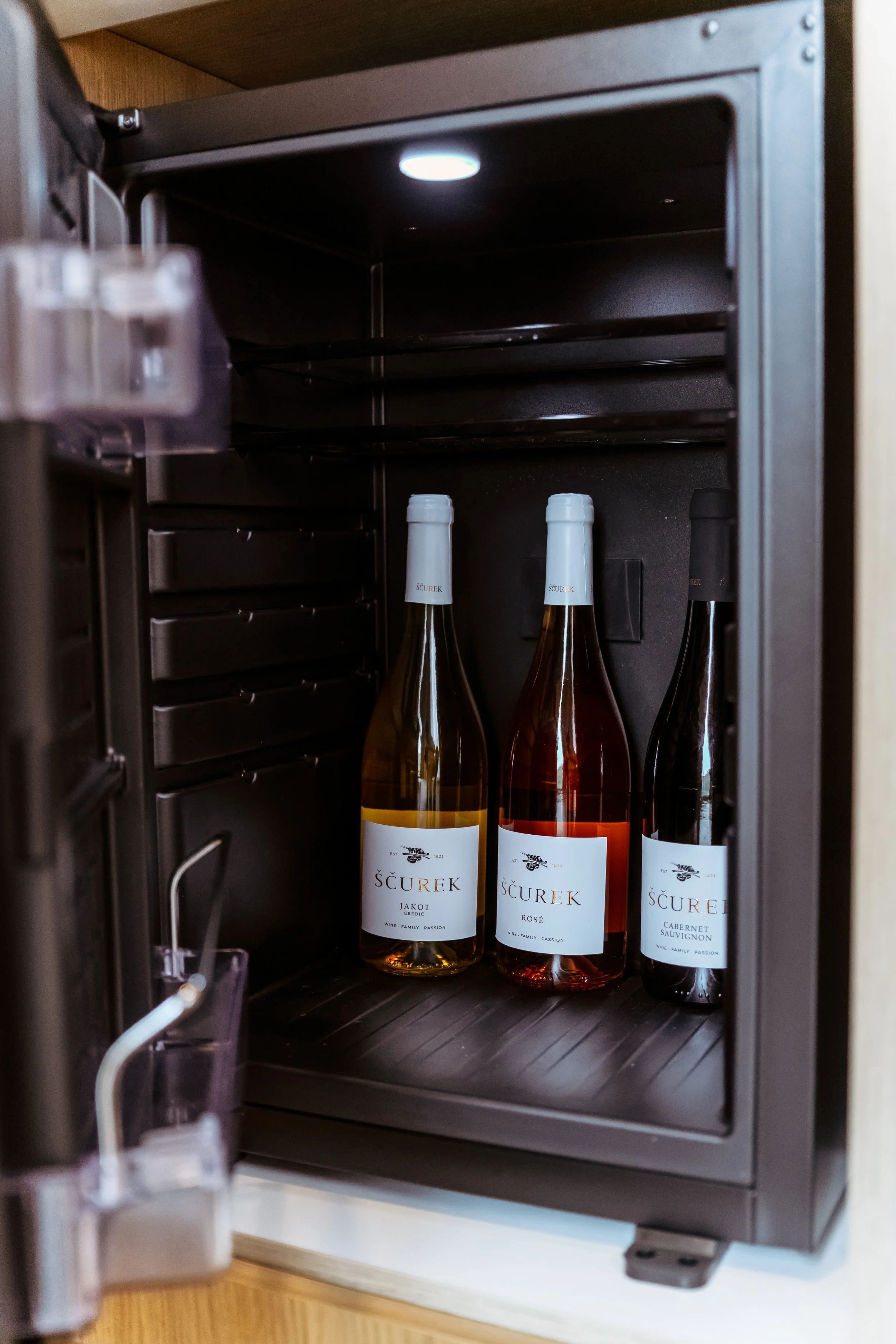 Three bottles of wine inside a mini wine cooler