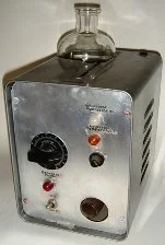 Ein altes elektronisches Gerät mit einem Glaskolben darauf, wahrscheinlich ein medizinisches Therapiegerät, mit mehreren Knöpfen und Schaltern auf der Vorderseite.