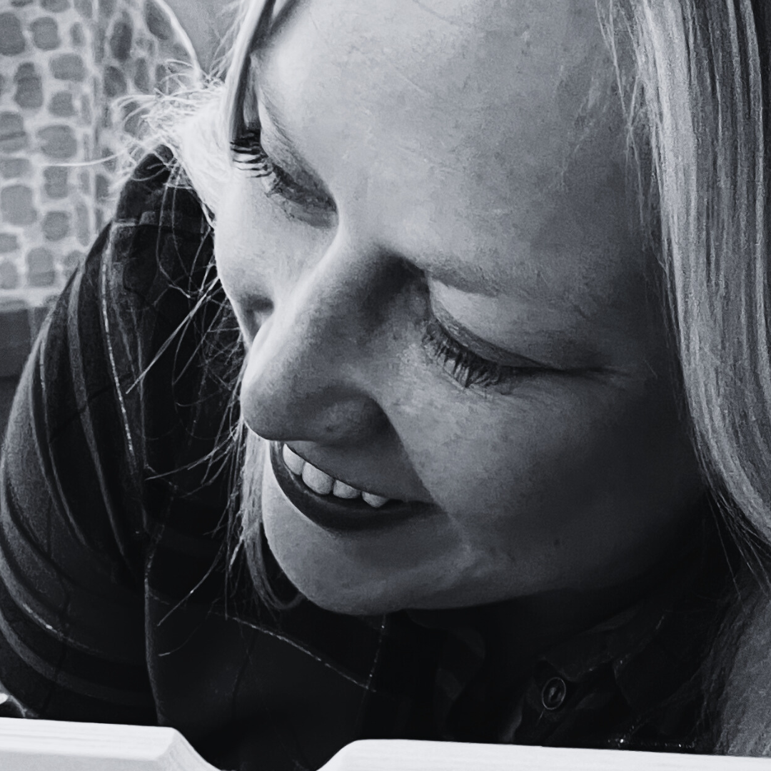 Vrouw met glimlach, zwart-wit foto, close-up gezicht, lezen of concentreren op iets voor haar.