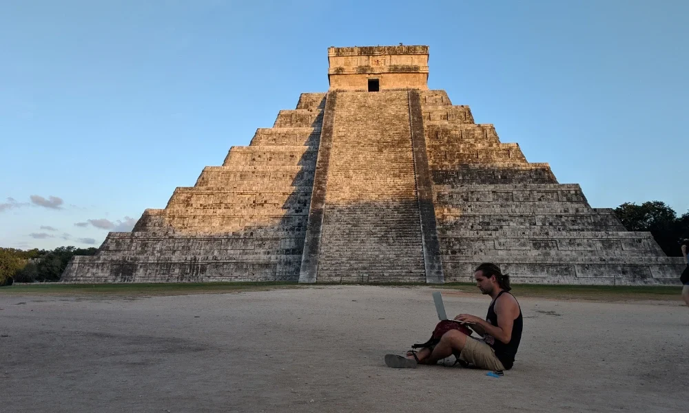 Man with laptop in front of Chichen Itza