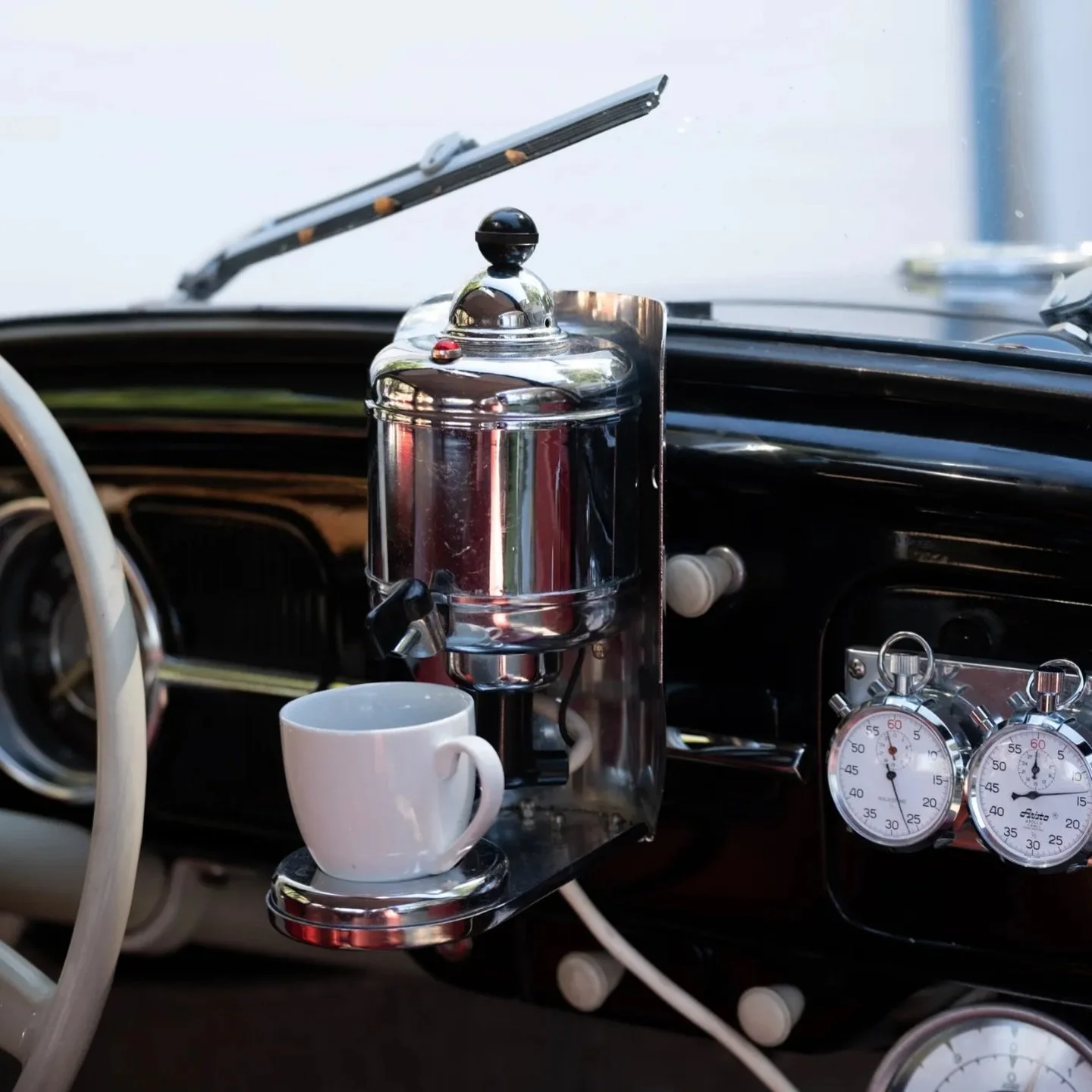 In 1959, Volkswagen offered a rare, optional dashboard-mounted coffee maker for Beetles and Buses called the Hertella Auto Kaffeemaschine, which plugged into the 6-volt system to brew drinks like coffee, tea, or broth using magnetic cups, making it a