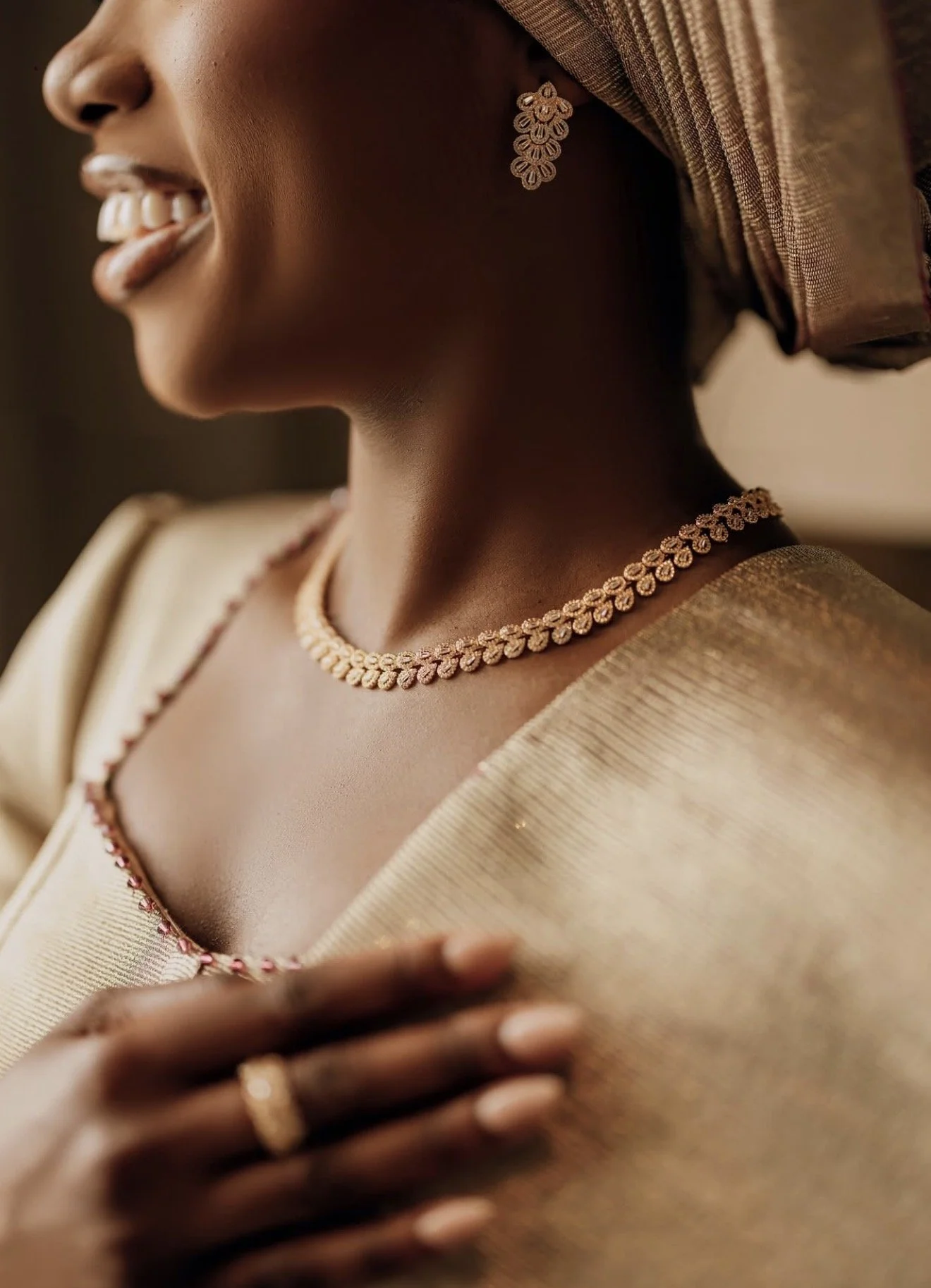 A joyful Nigerian couple dressed in traditional purple attire, surrounded by friends and family in colorful, festive clothing at a celebration or wedding.