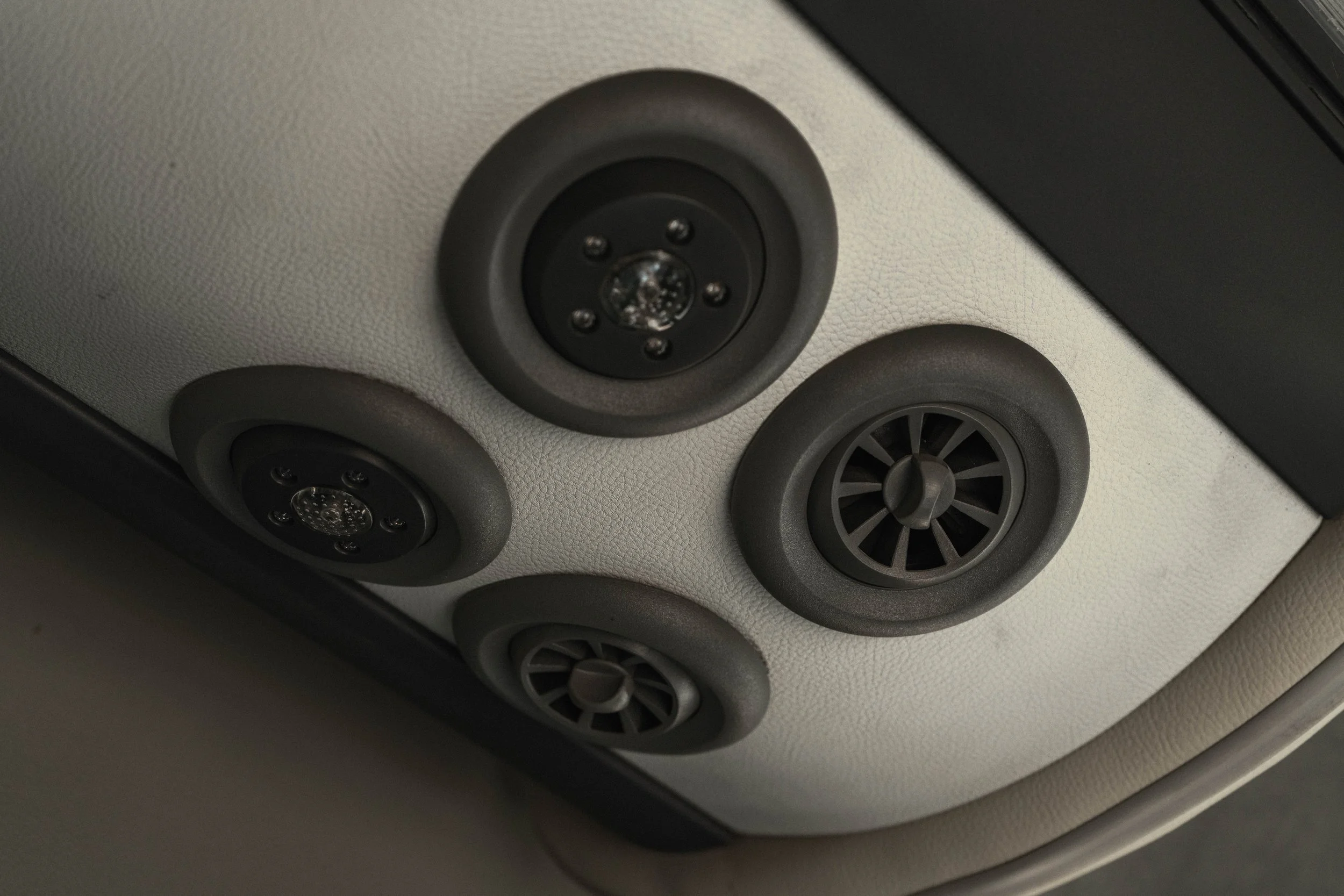 Revestimento de teto de carro com quatro difusores de ar, dois com saídas de ar e dois de LEDs.