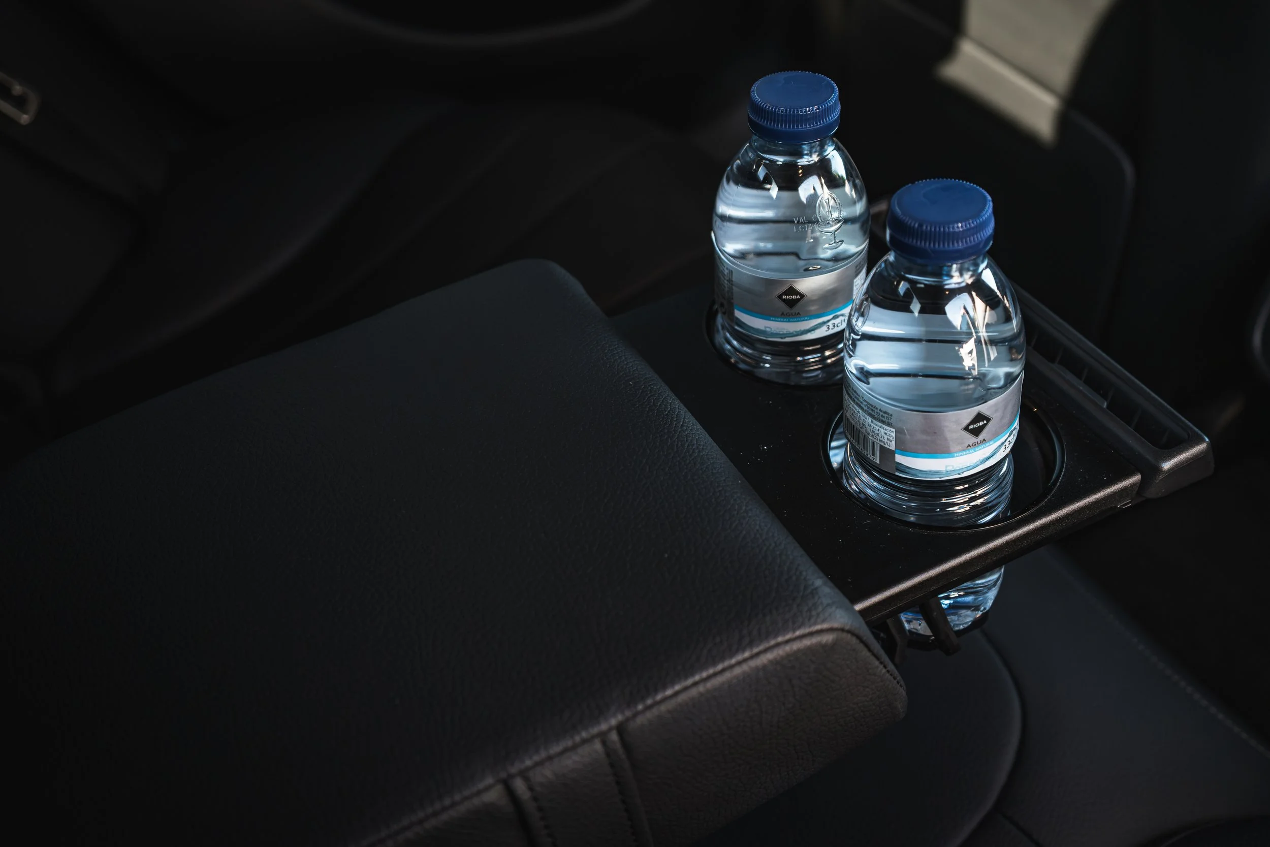 Duas garrafas de água em um porta-retratos no interior de um carro.