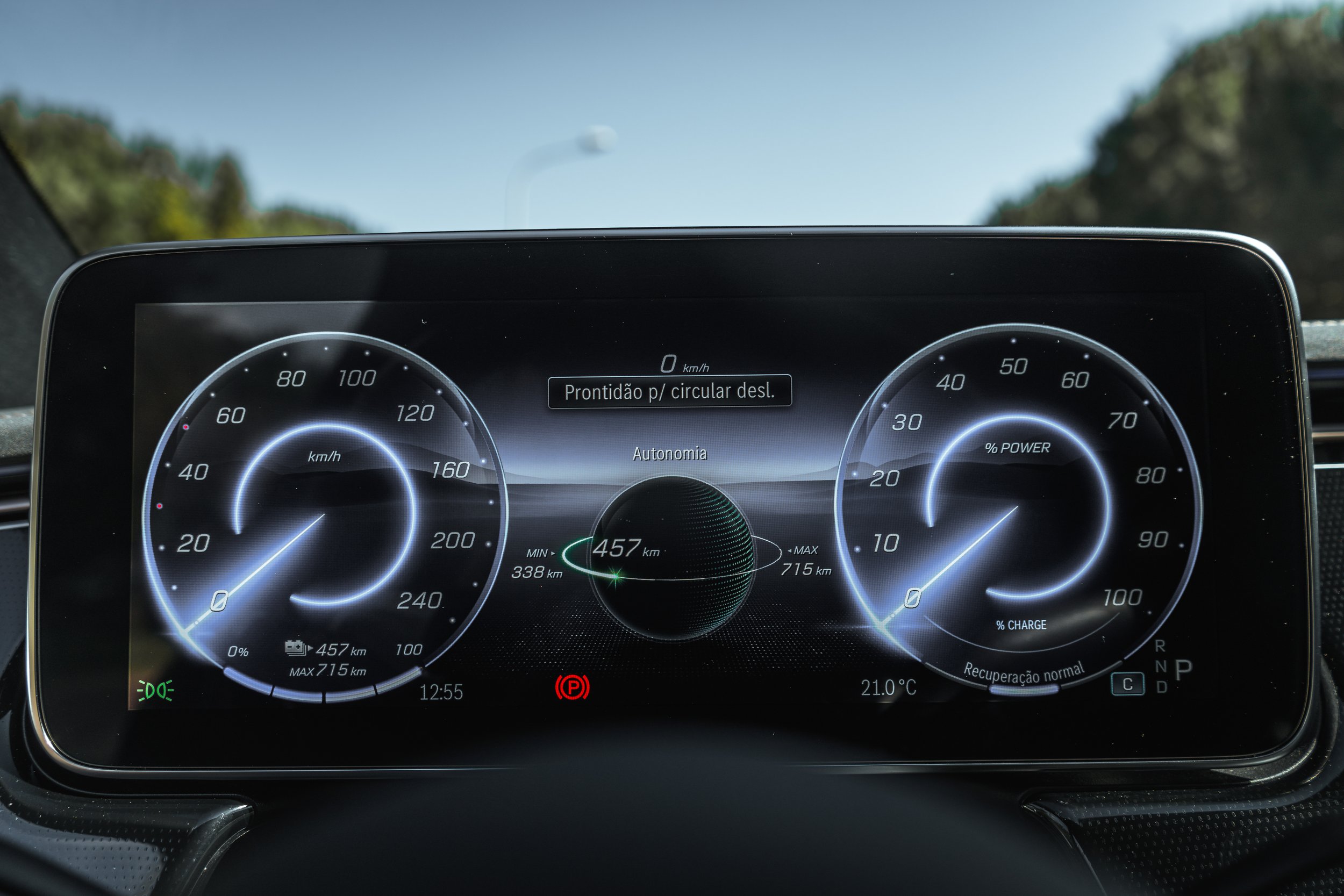 Painel digital de velocidade e autonomia de carro, mostrando 0 km/h, 457 km de autonomia, temperatura de 21°C, e outros indicadores.