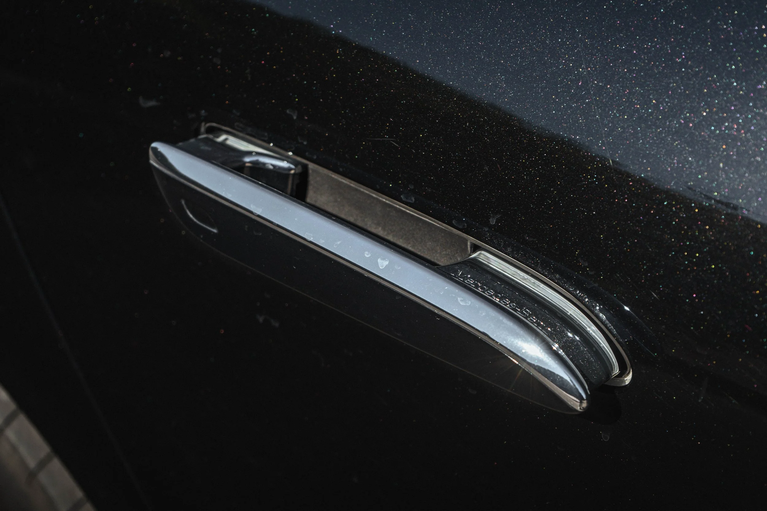 Maçaneta de carro preta com detalhes cromados, na cor preta com glitter.