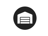 Garage icon with black circle background, representing a building with a closed garage door.