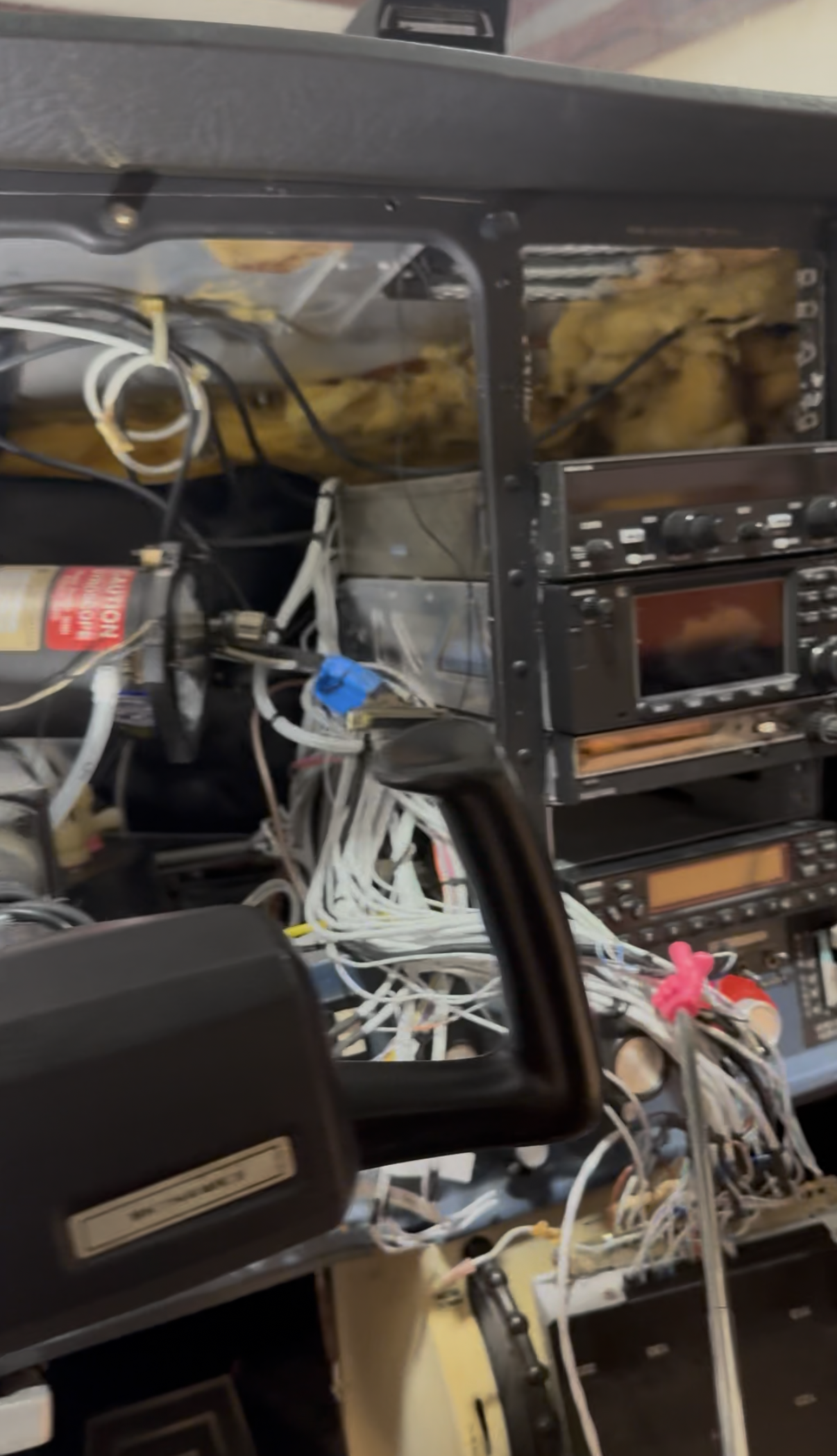 Inside an electronic device with various wires, circuit boards, and components, including a control panel with knobs and a display, indicating a disassembled or repair state.
