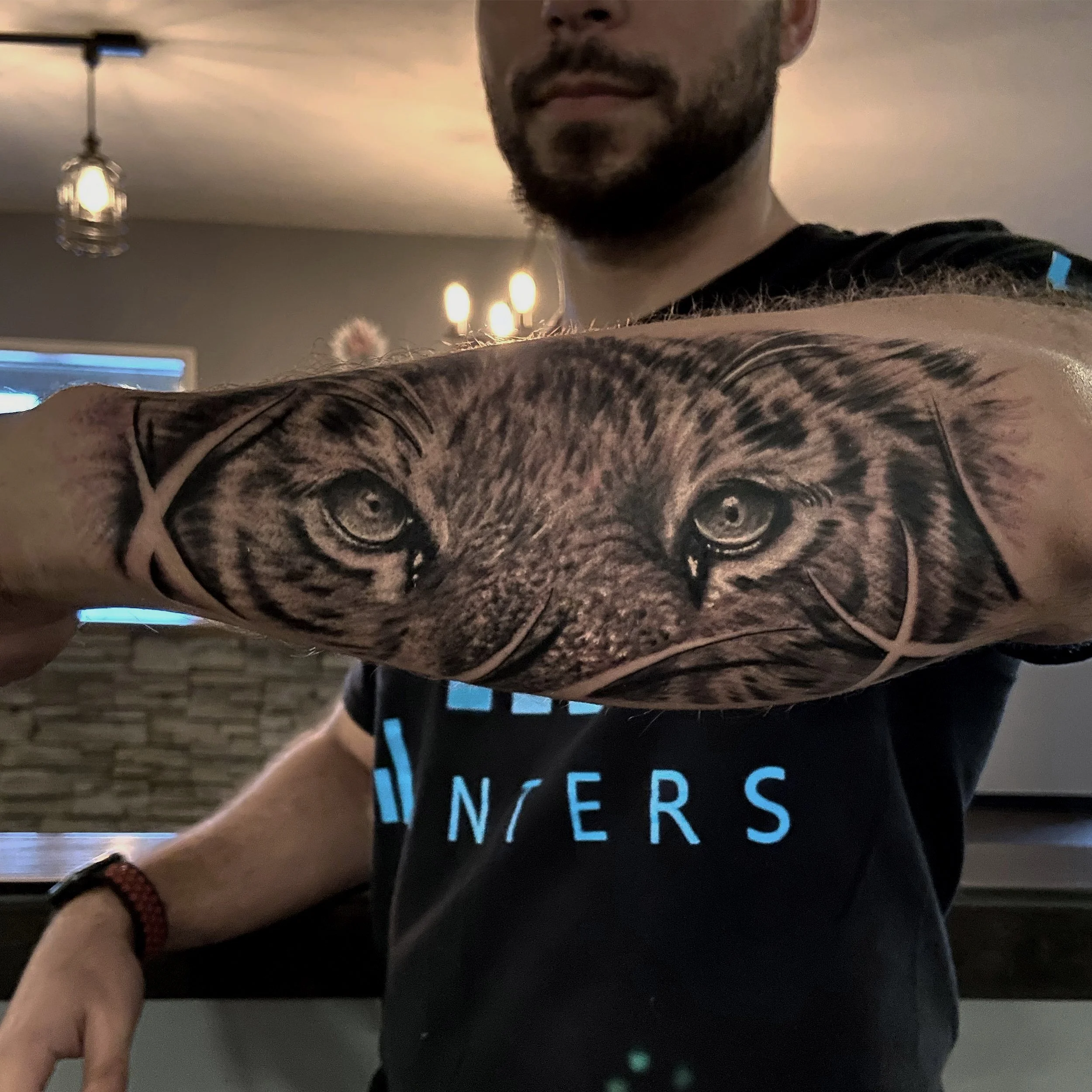 Close-up of a person's arm tattoo depicting a realistic lion's face with piercing eyes.