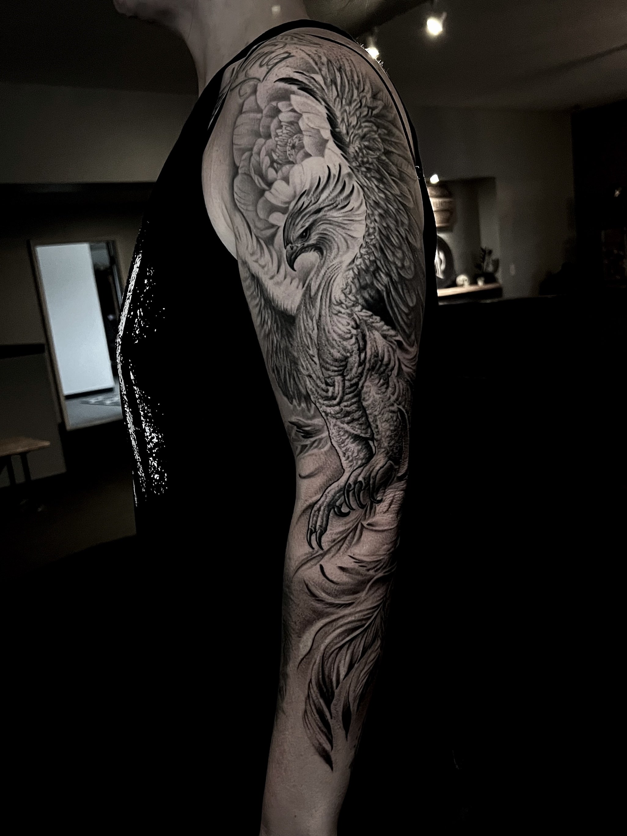 Close-up of a detailed black and gray tattoo of a majestic eagle on a person's upper arm.