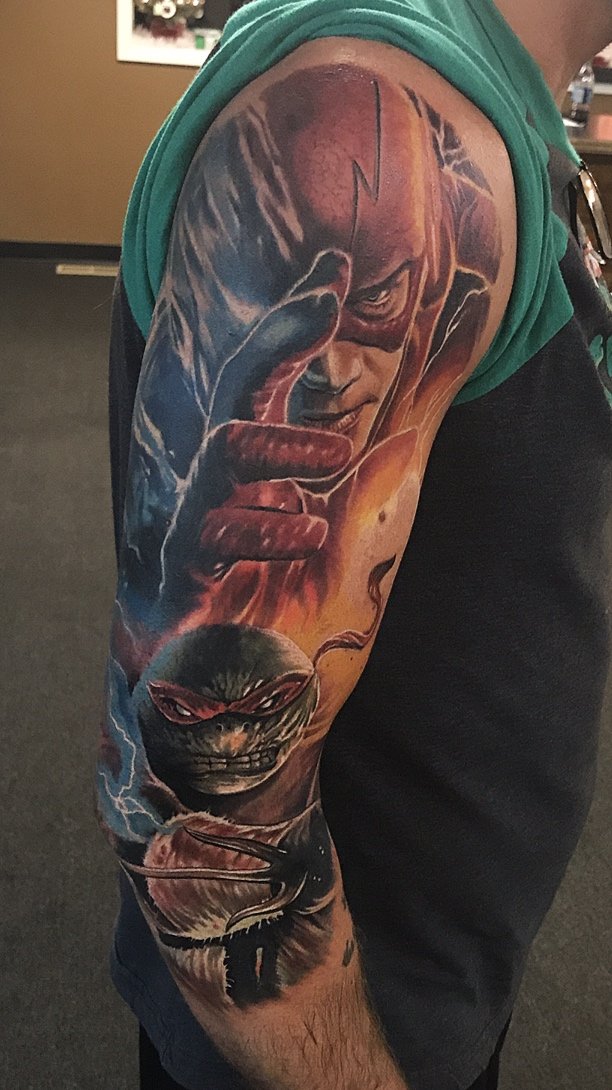 Colorful tattoo of The Flash and Teenage Mutant Ninja Turtles on a man's arm.