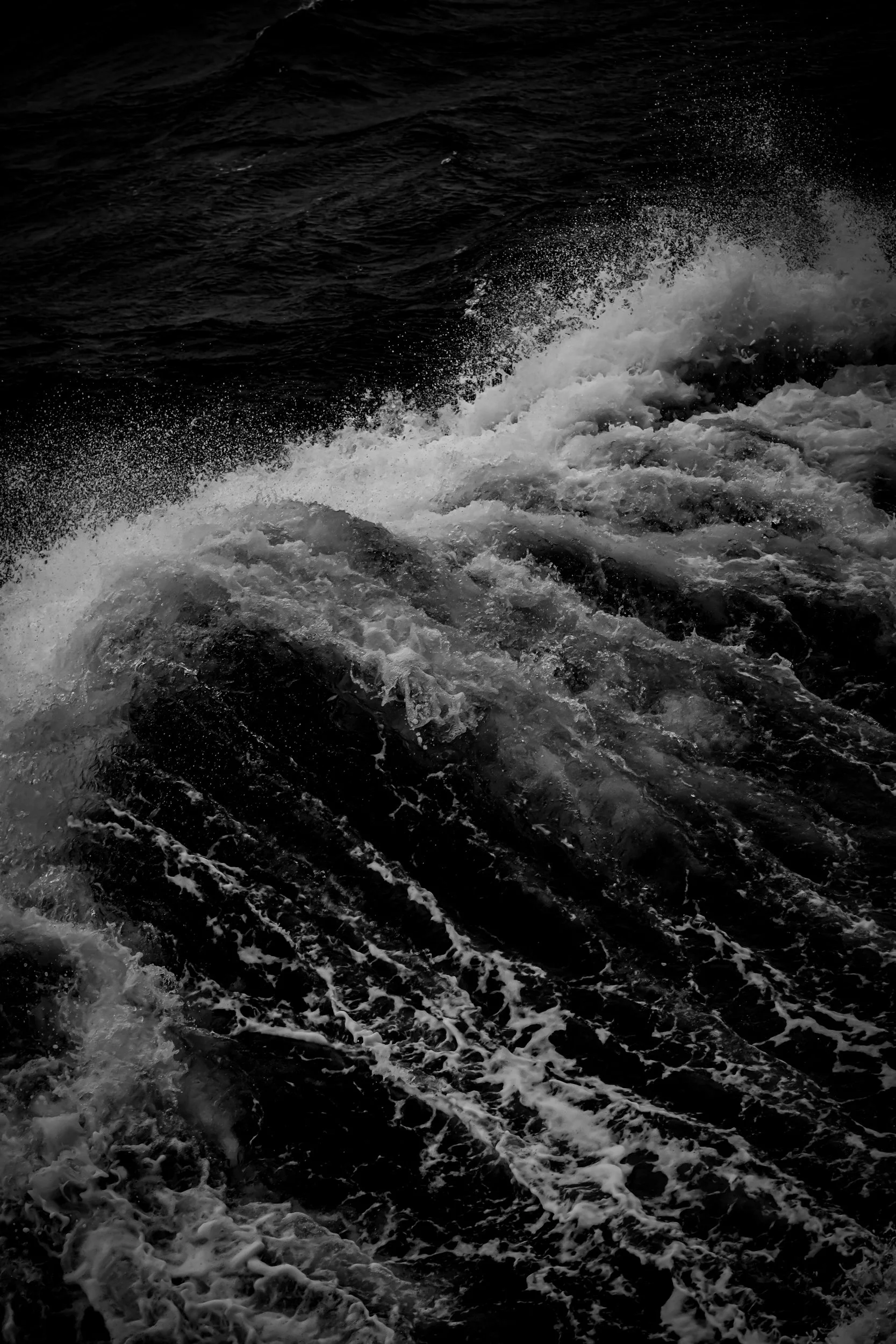 Dark ocean water with waves and white foamy sea spray