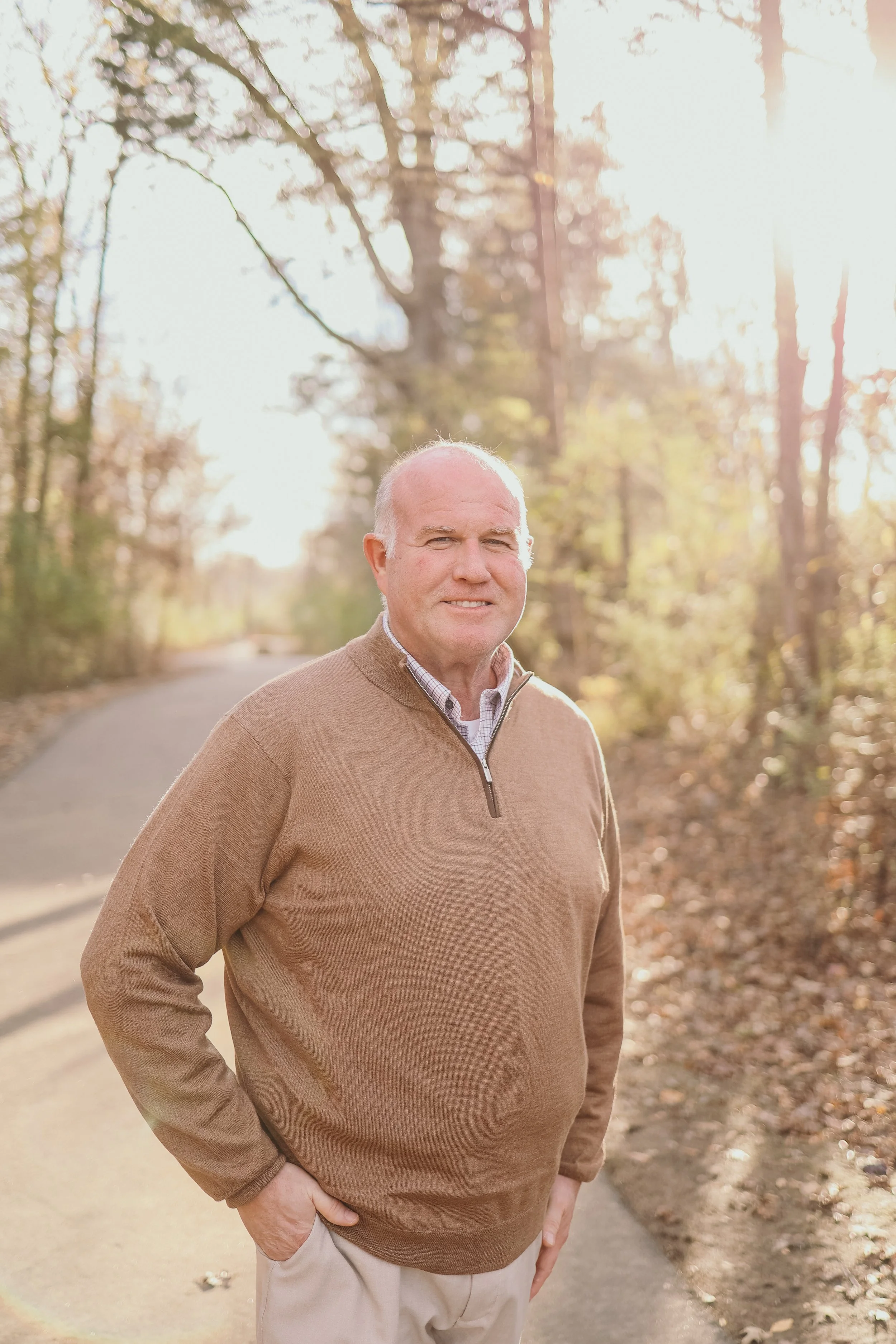 A man wearing quarter zip in country setting.