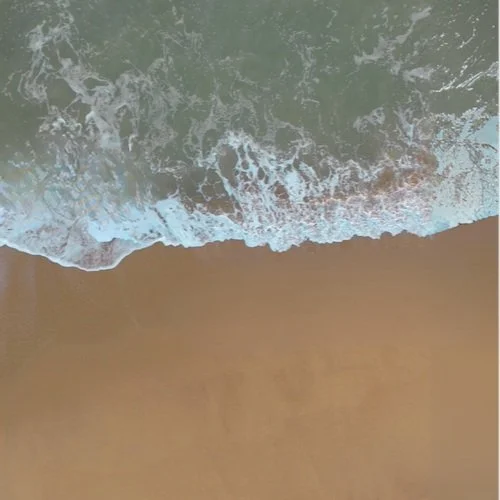Ocean waves crashing on sandy beach