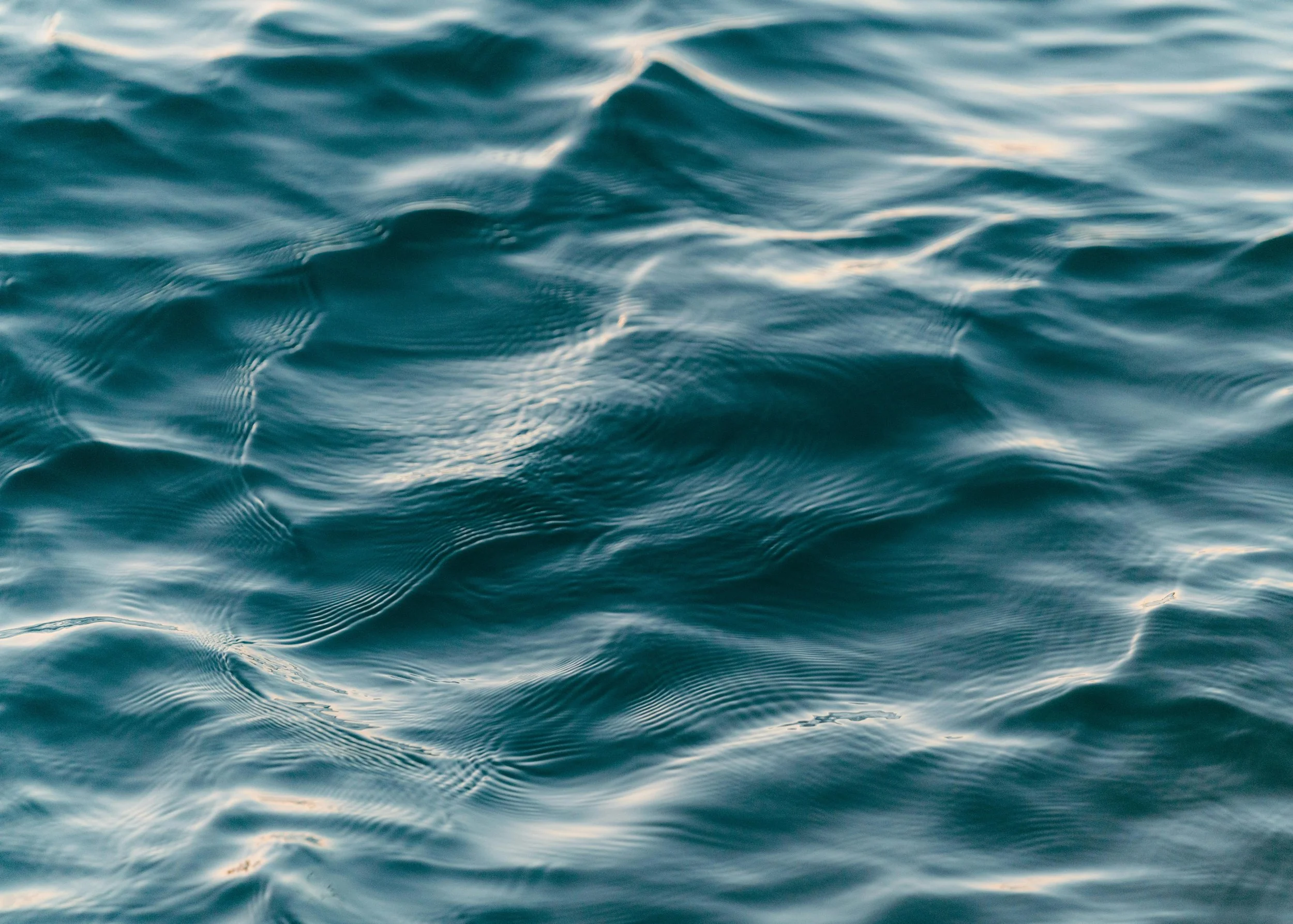 Close-up of ocean water with gentle waves and sunlight reflections.