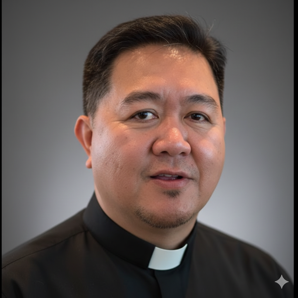 A man wearing a black clerical shirt and white clerical collar, smiling slightly, with a plain gray background.