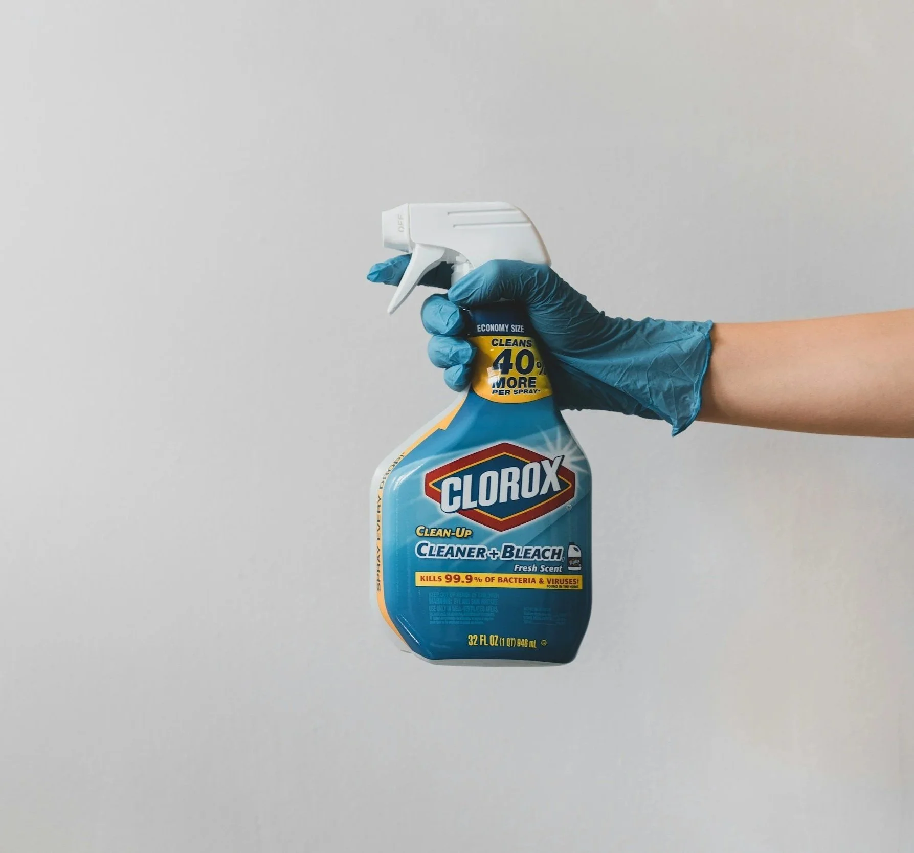 A red beverage in a glass with ice cubes and a sprig of rosemary on top, viewed from above against a white background.