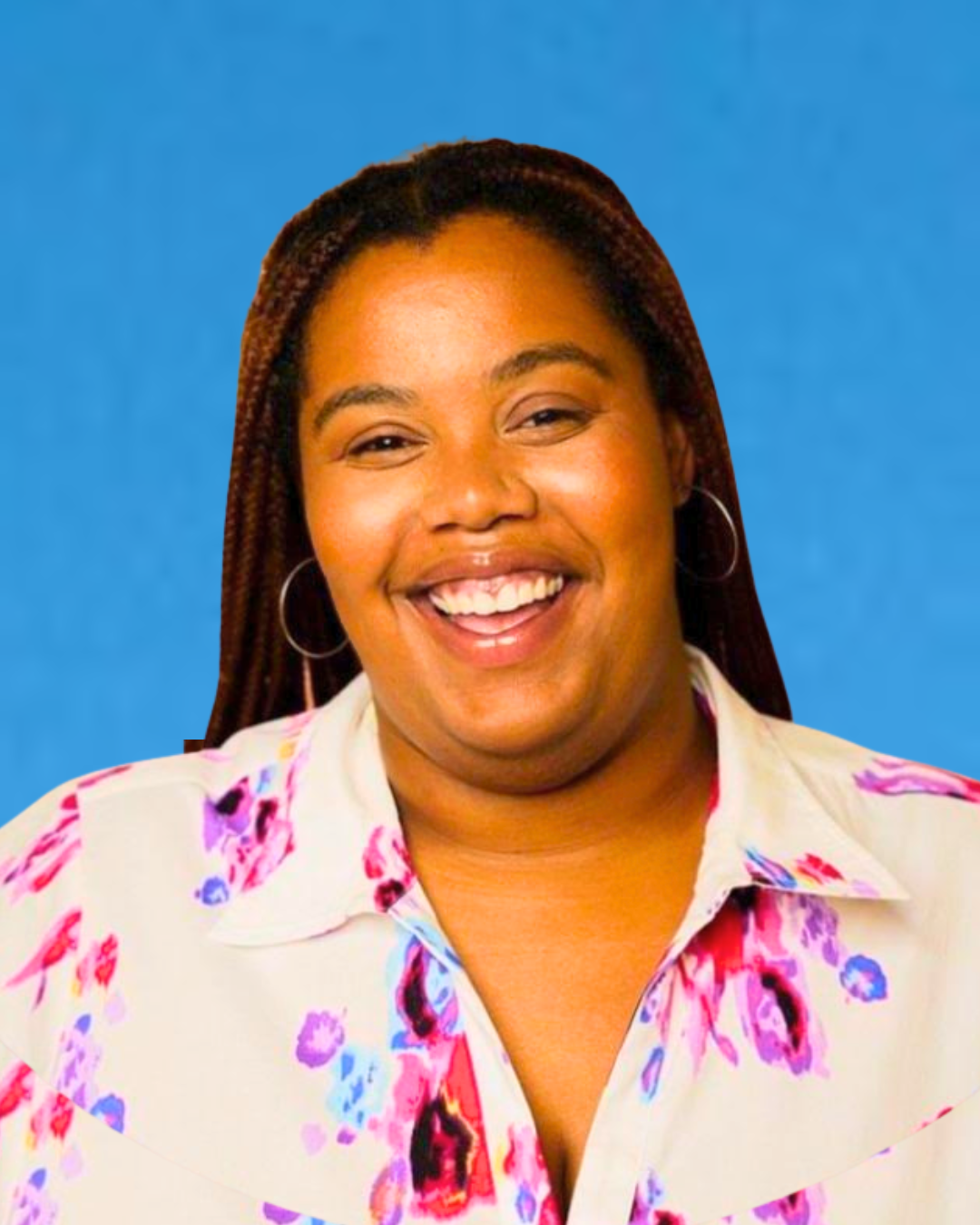 A woman smiling with long braided hair, wearing hoop earrings and a white shirt with a colorful floral pattern, against a plain blue background.