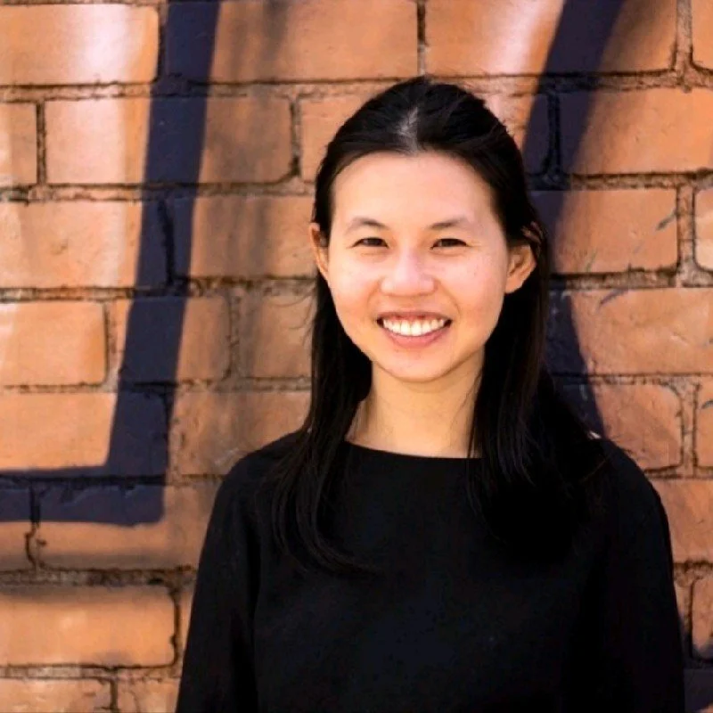 An image of Tienyi Long smiling at the camera. She is wearing a black top.