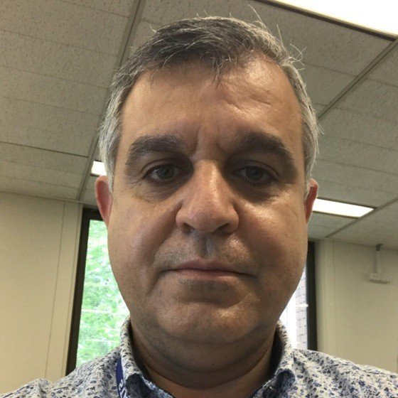 An image of Dr. Khaldoon Fahmi looking at the camera in a collared top.