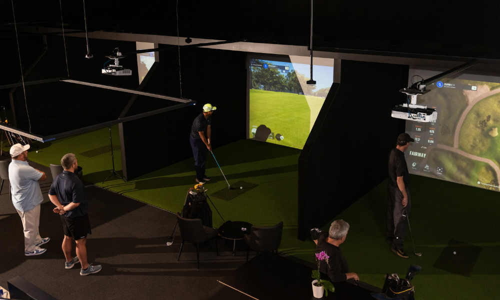 A group of friends enjoying a round of golf together on TrackMan simulators at The Range, Christchurch’s indoor golf centre.