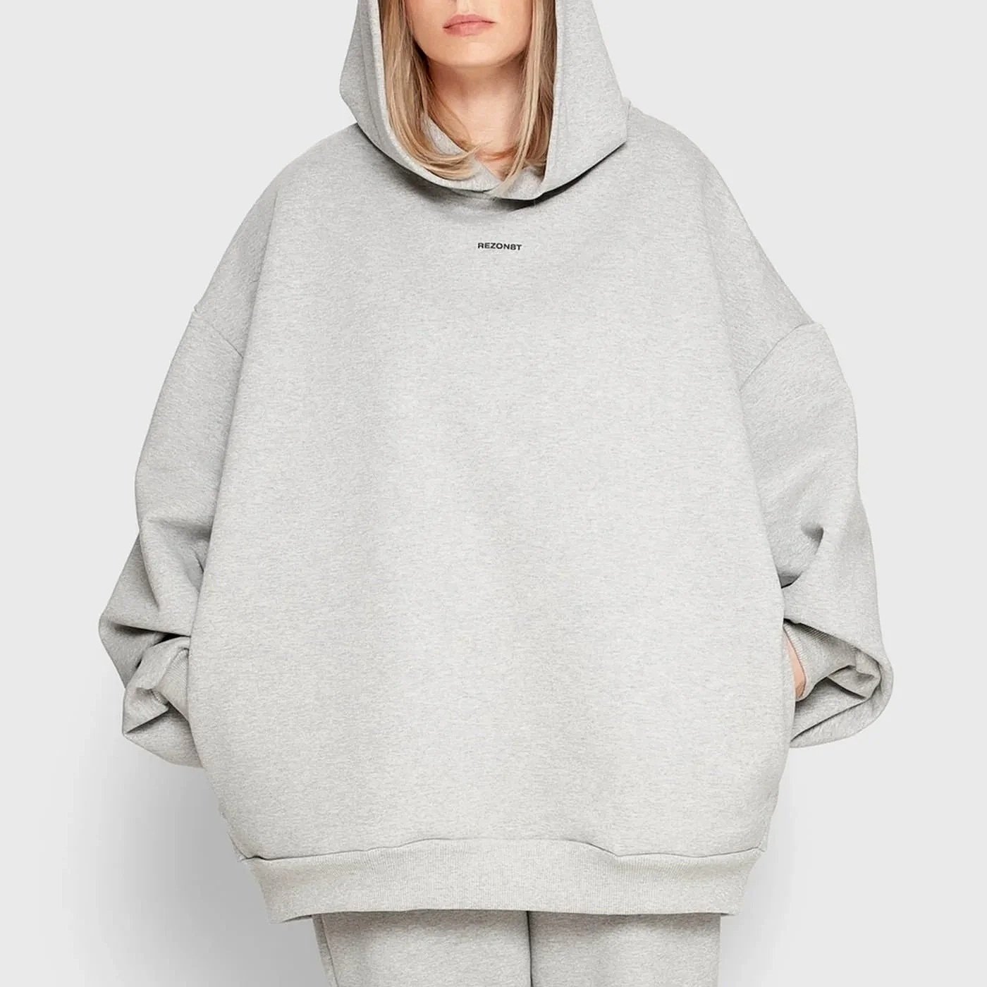 Model wearing REZON8T ESSENCE Collection oversized hoodie in grey — premium 100% French terry cotton, designed in Denmark and crafted in Europe. Limited-edition minimalist streetwear.